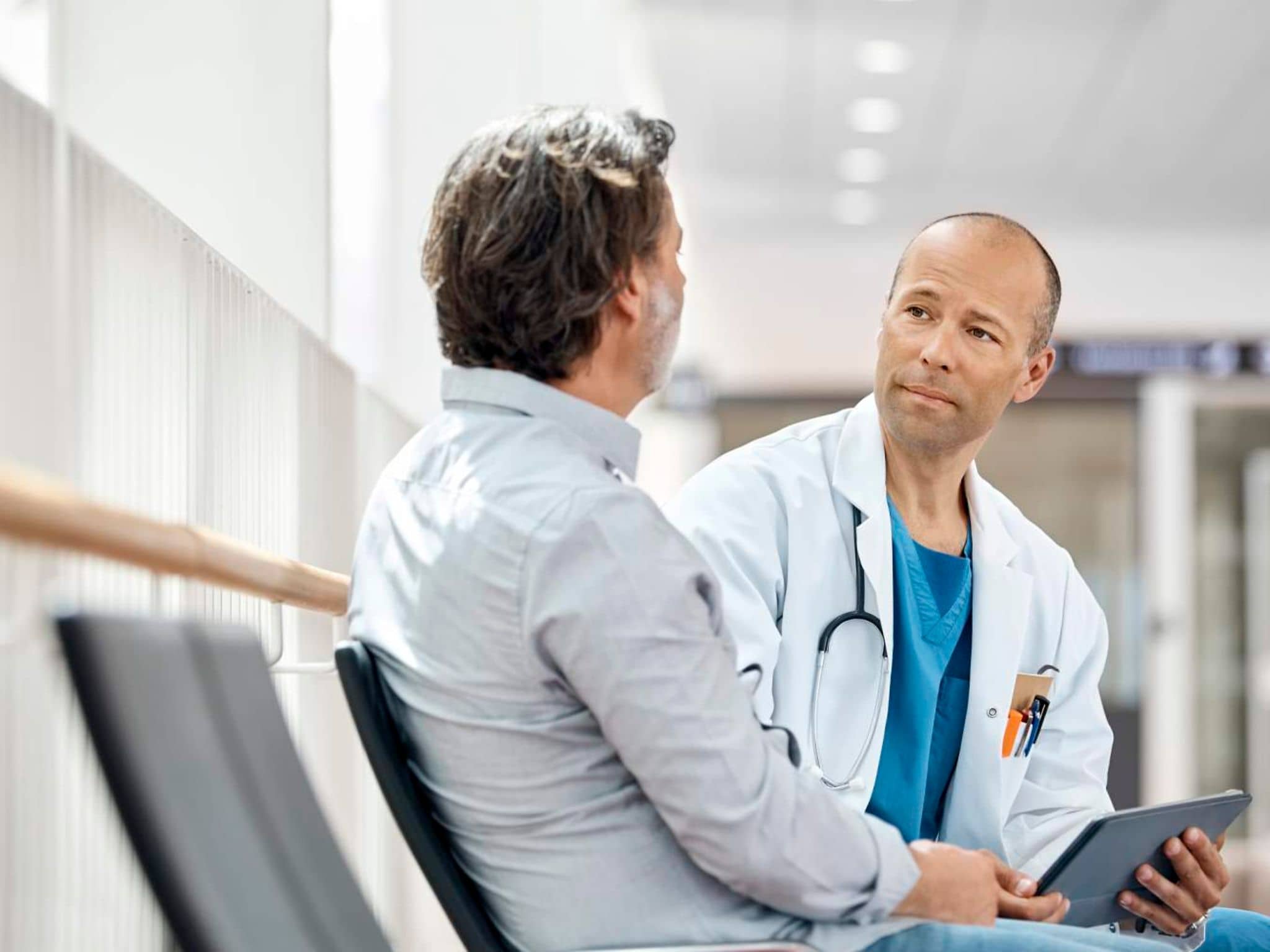 Zweitmeinung: Patient unterhält sich mit einem Arzt.