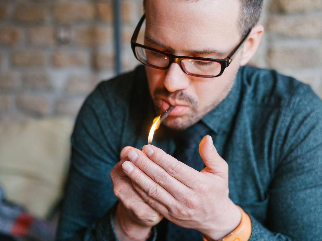 Lungenkrebs: Mann zündet sich eine Zigarette an.