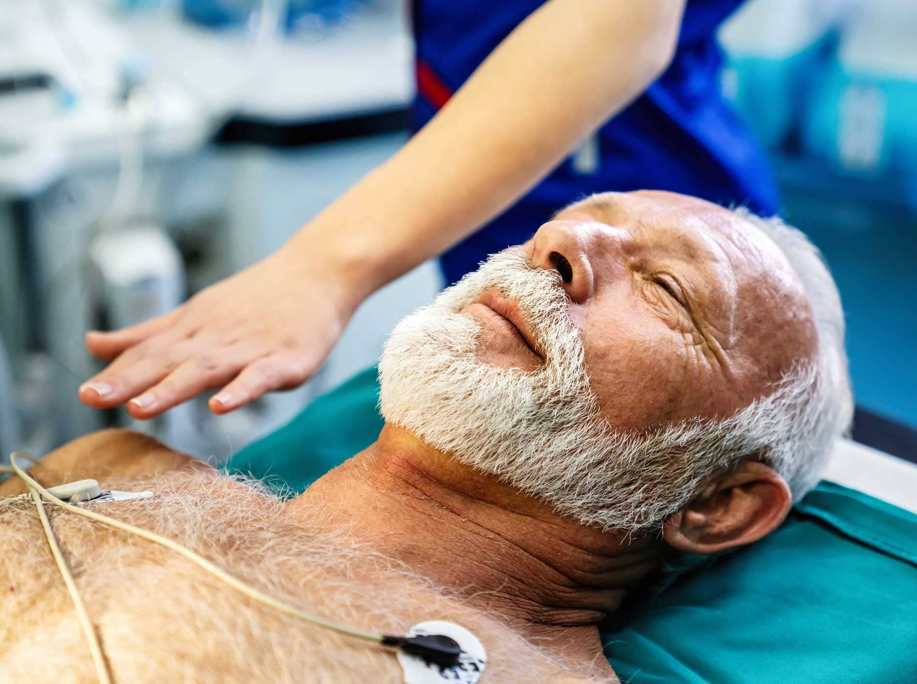 Älterer Mann liegt verkabelt auf einem Operationstisch.