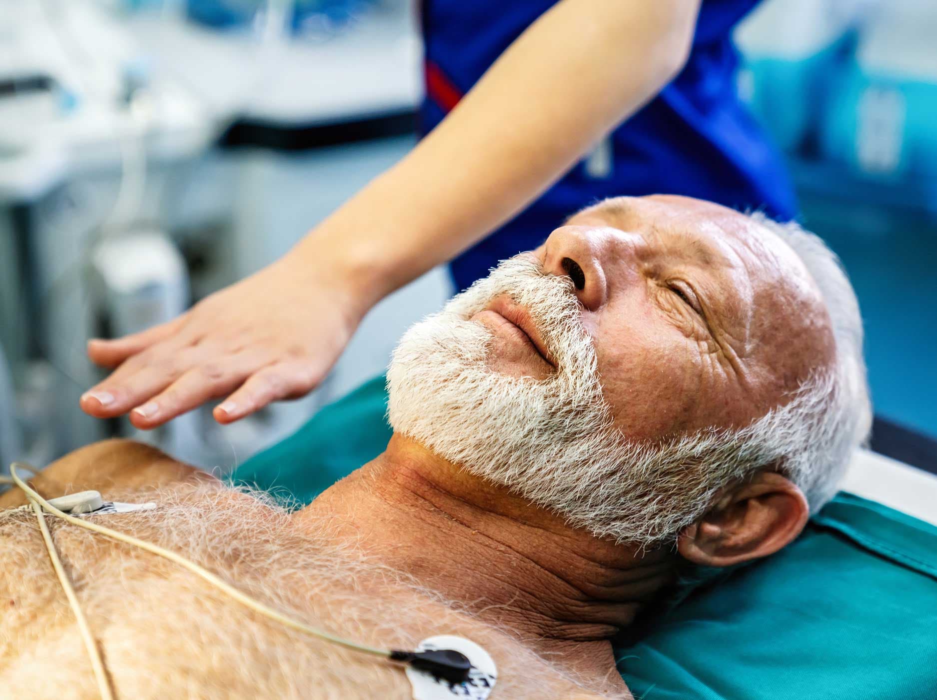Älterer Mann liegt verkabelt auf einem Operationstisch.
