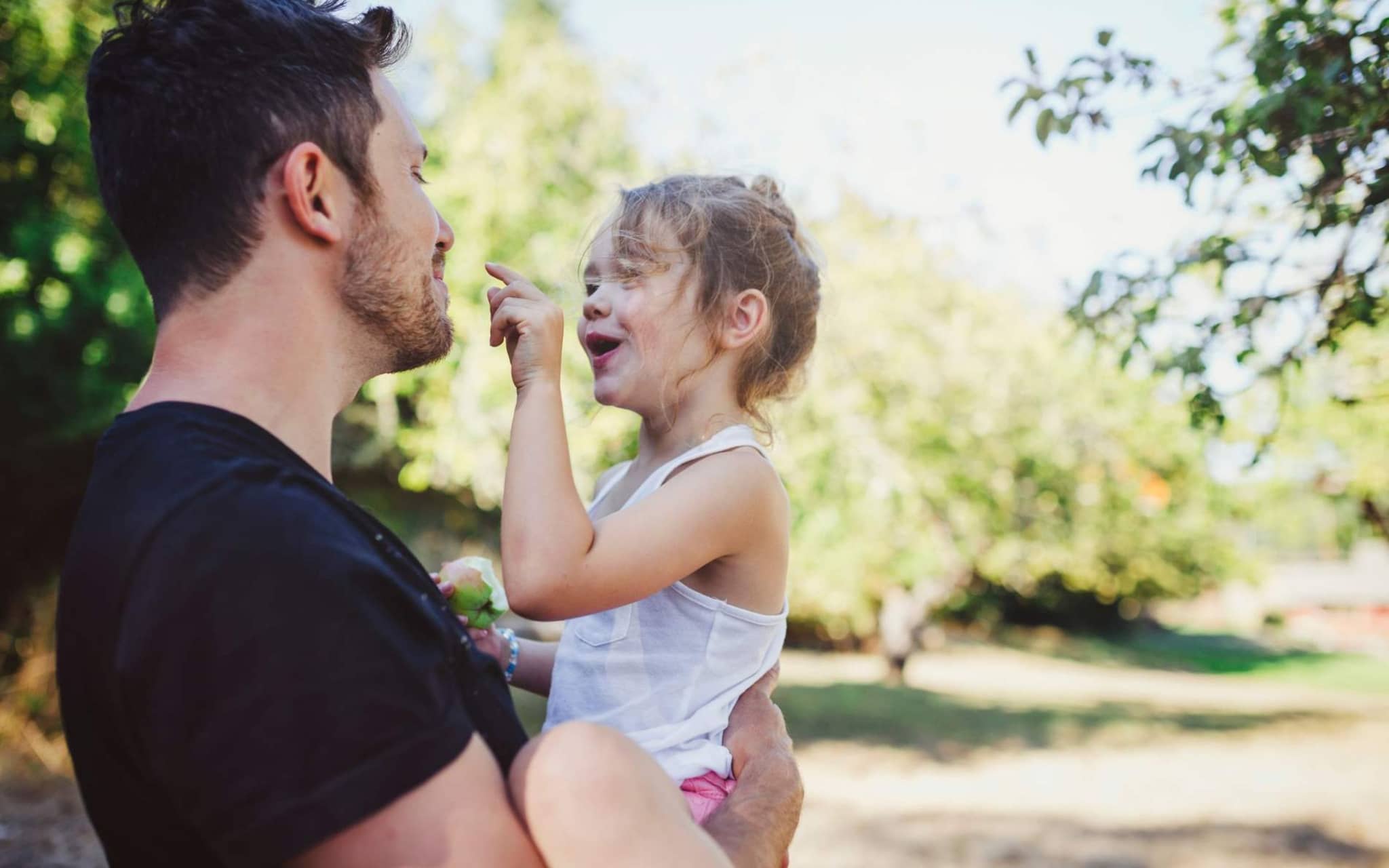 AktivBonus für Kinder: Vater mit Tochter auf dem Arm im Freien.