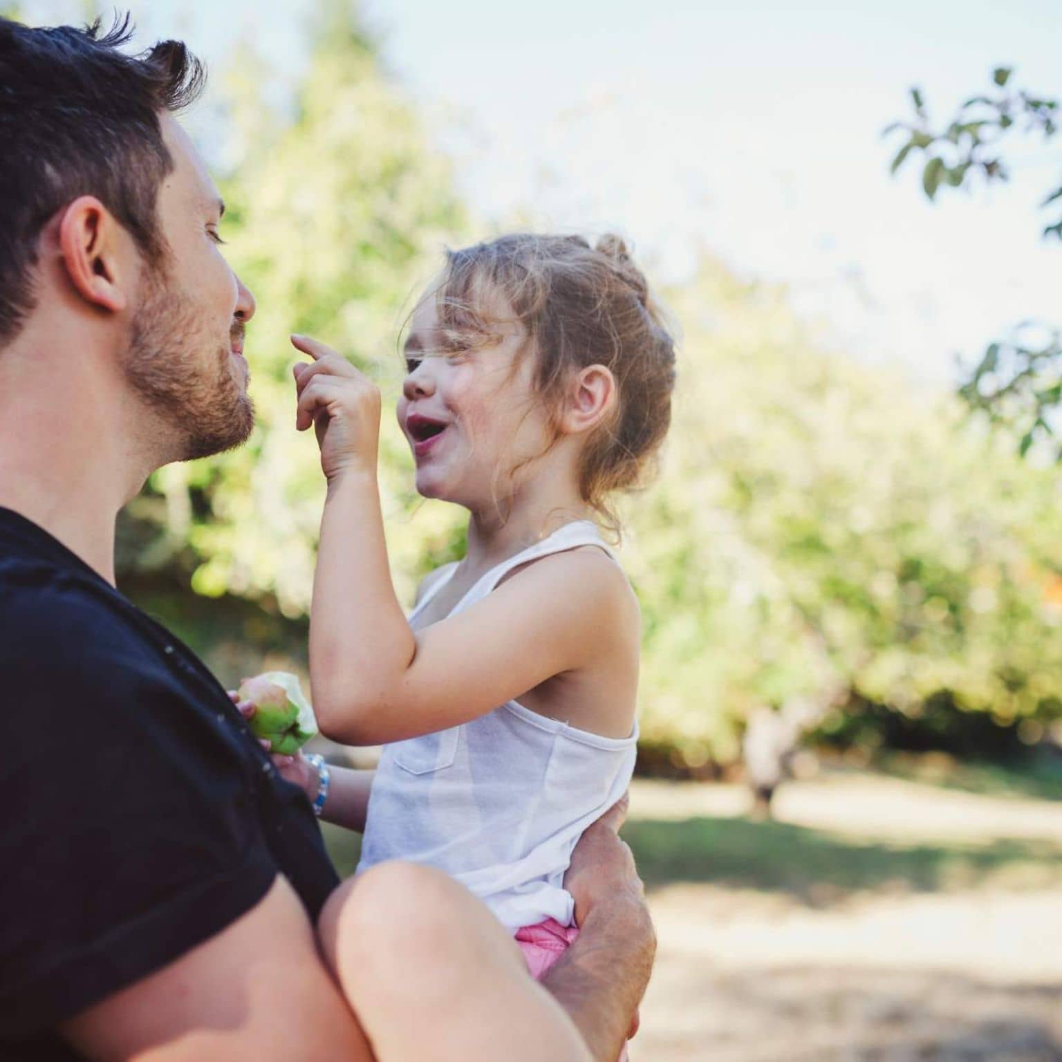 AktivBonus für Kinder: Vater mit Tochter auf dem Arm im Freien.