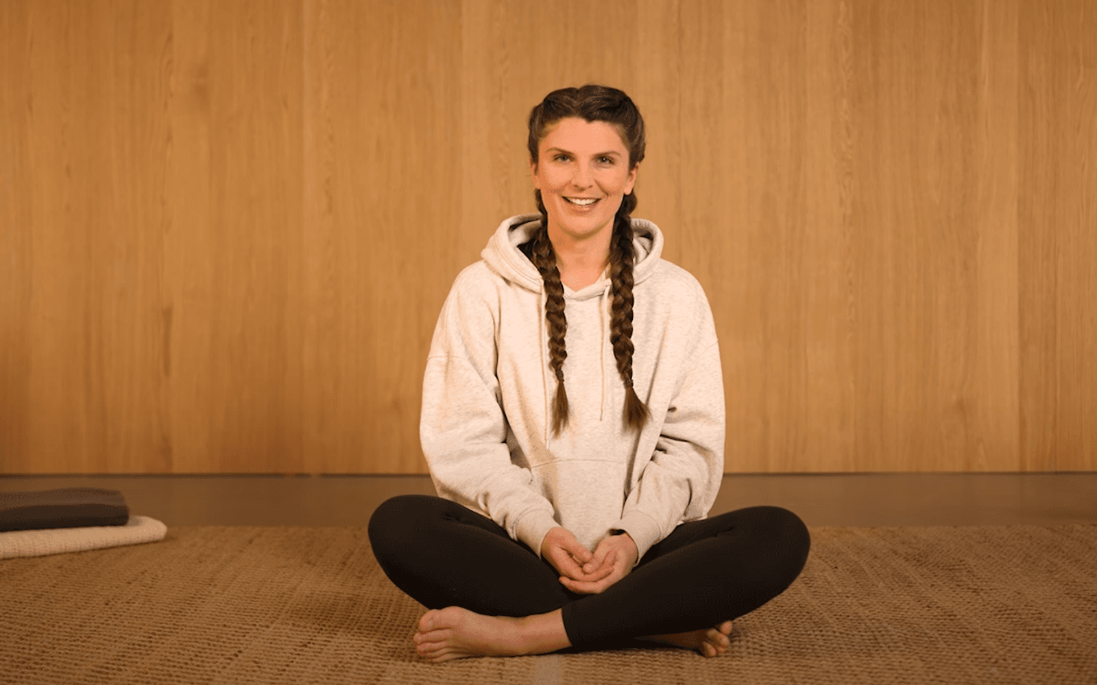 Bild: Yoga-Lehrerin Lena Zimmerman sitzt im Schneidersitz auf dem Boden.