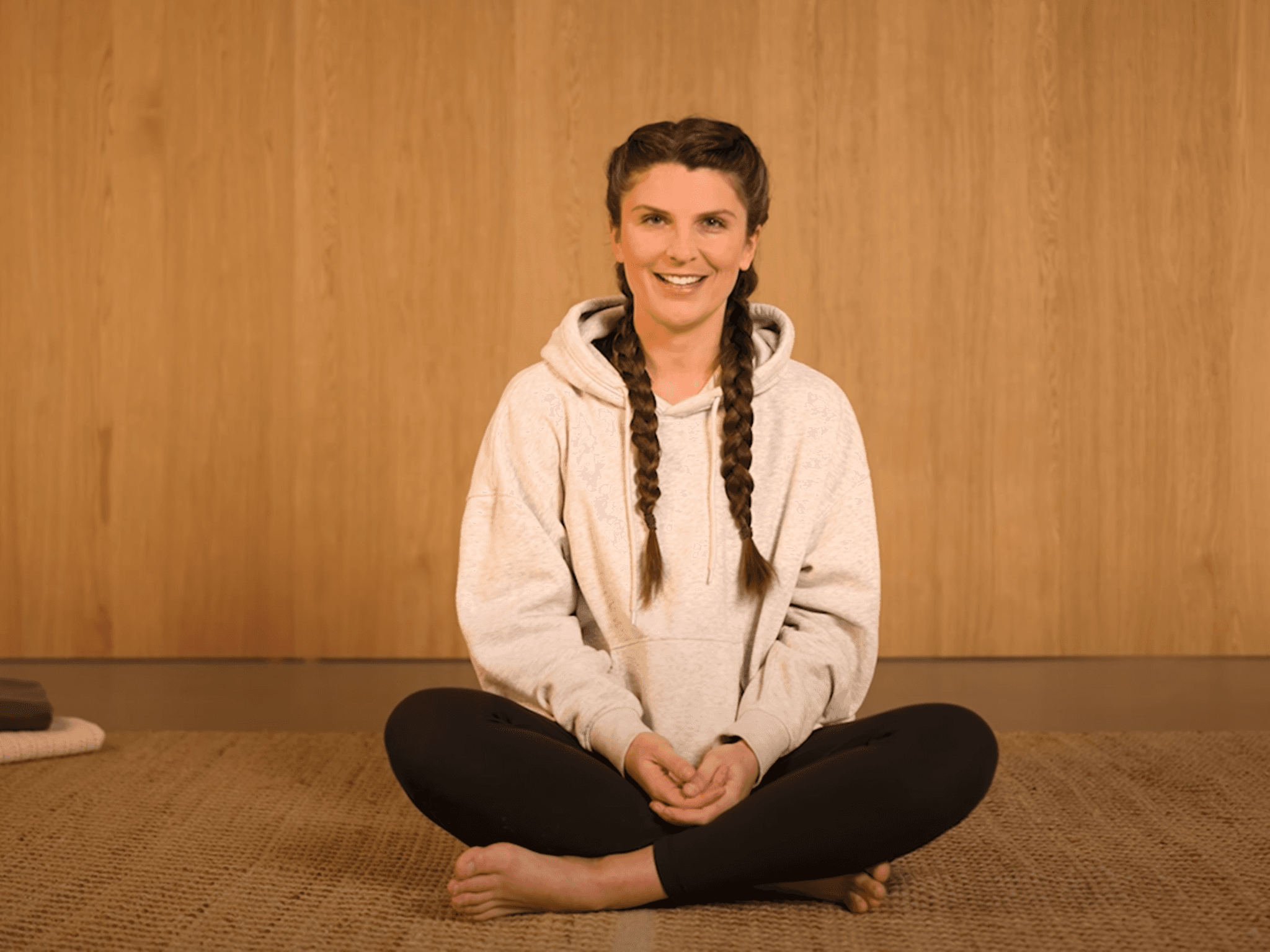 Bild: Yoga-Lehrerin Lena Zimmerman sitzt im Schneidersitz auf dem Boden.