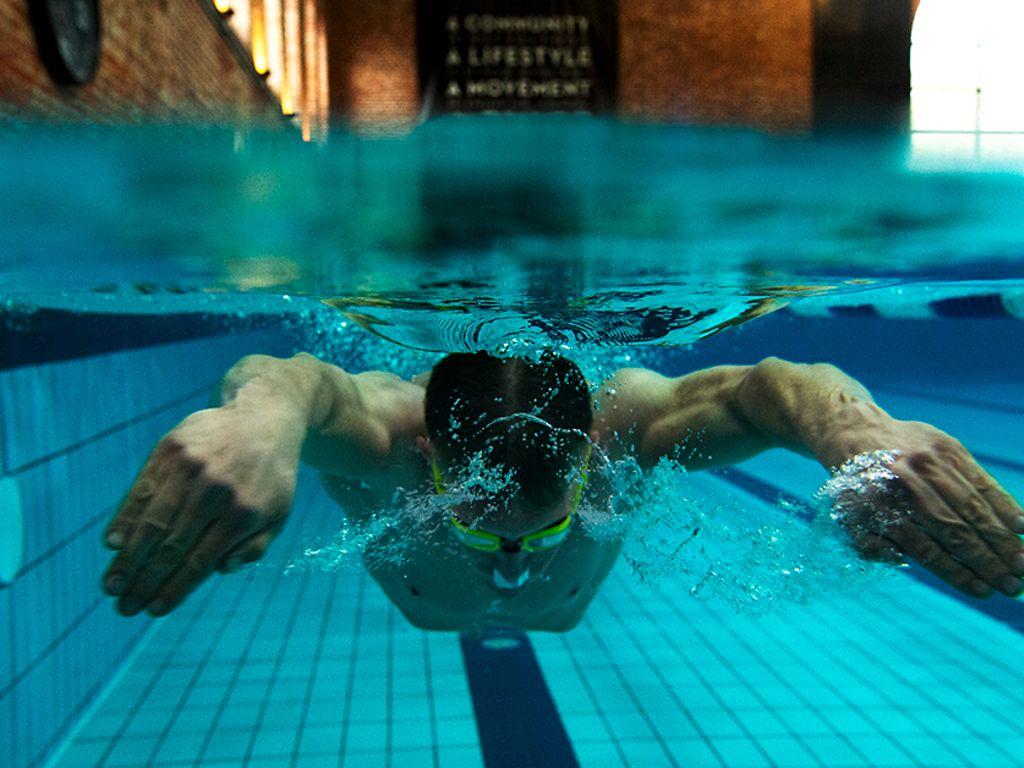 Brustschwimmen: Ein Mann schwimmt in einem Hallenbad unter Wasser