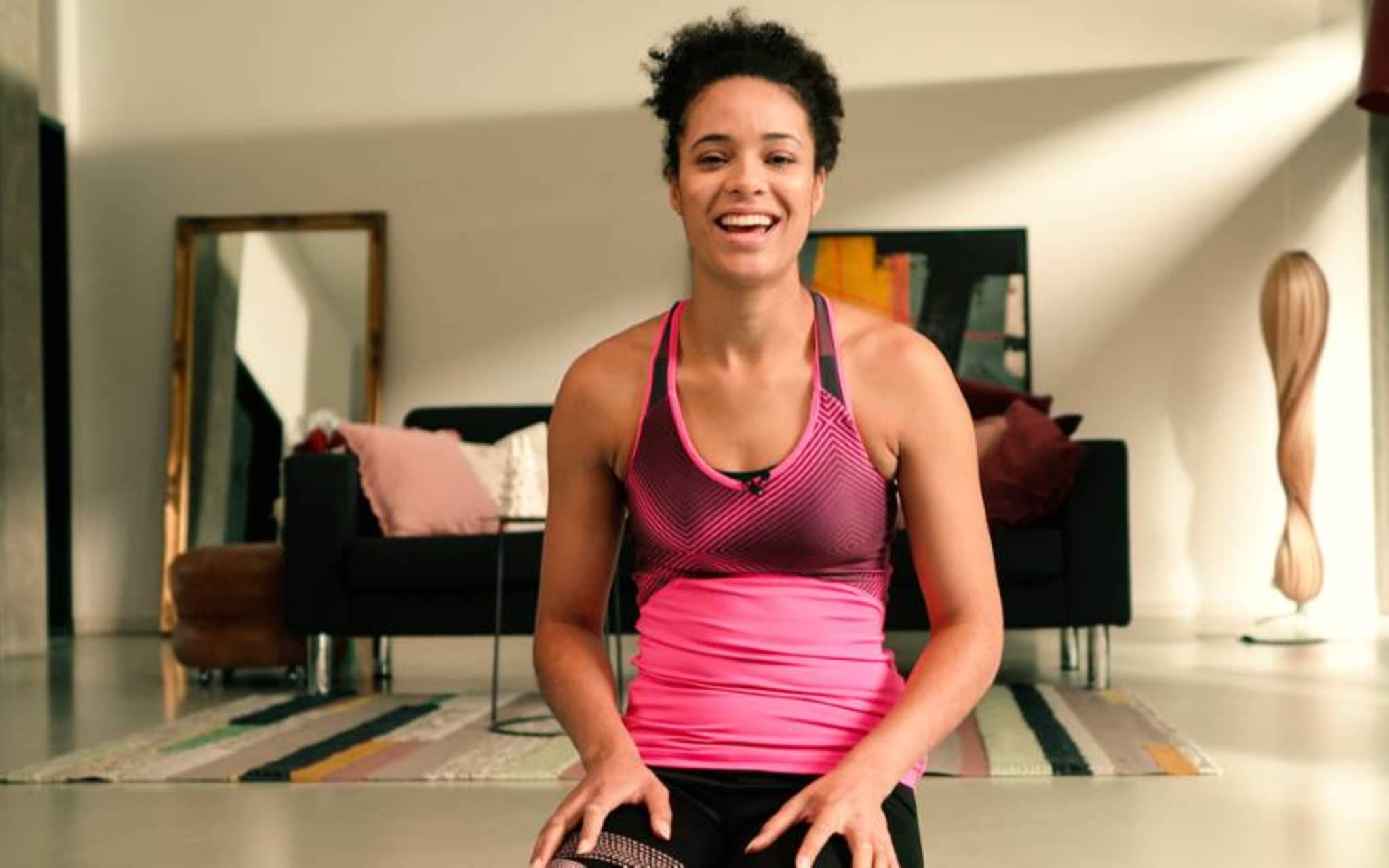 Marie-Laurence Jungfleisch kniet in Sportkleidung auf dem Boden und blickt in die Kamera