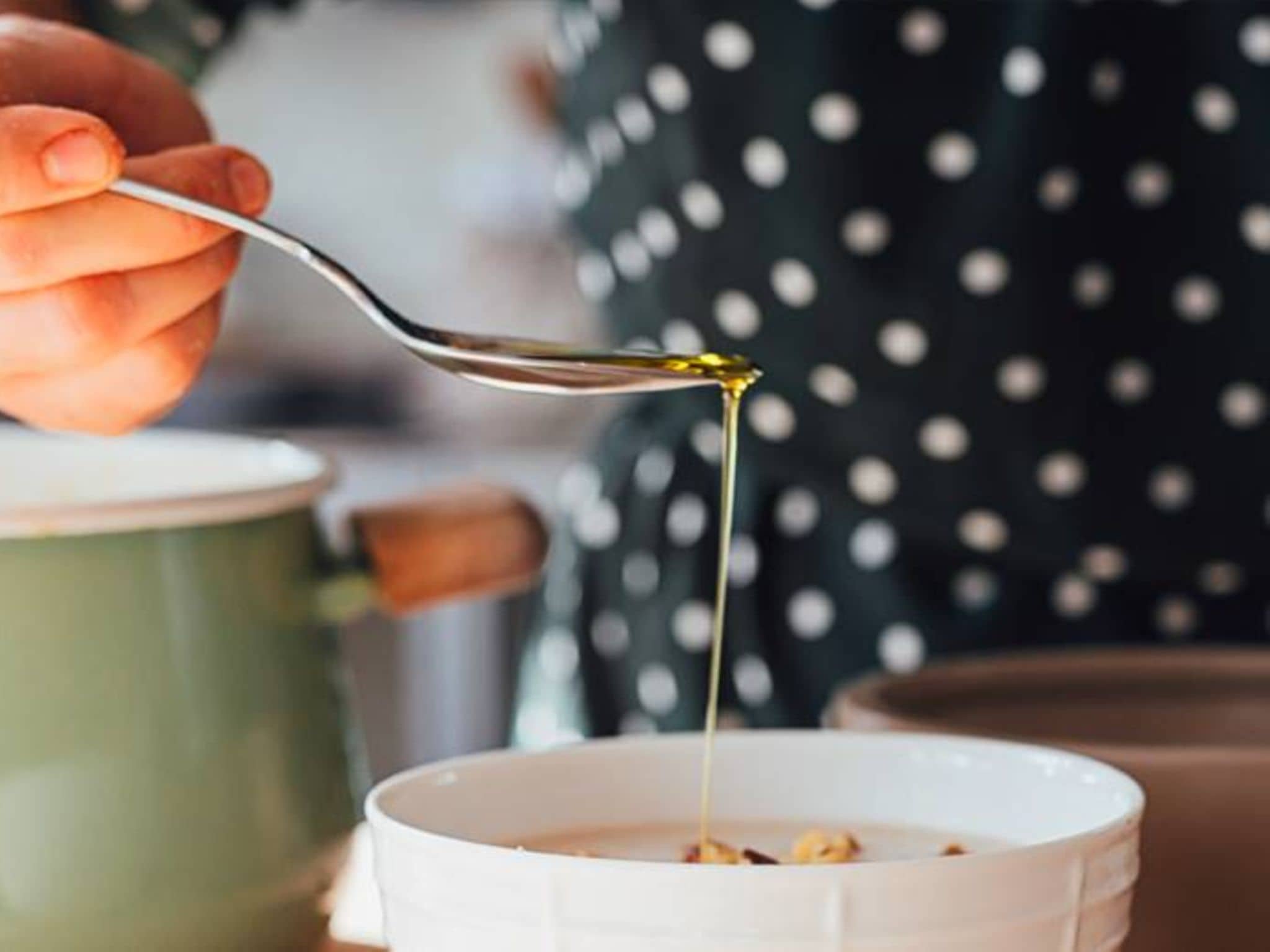 Gesunde Fette: Von einem Löffel läuft Öl in eine Suppenschale