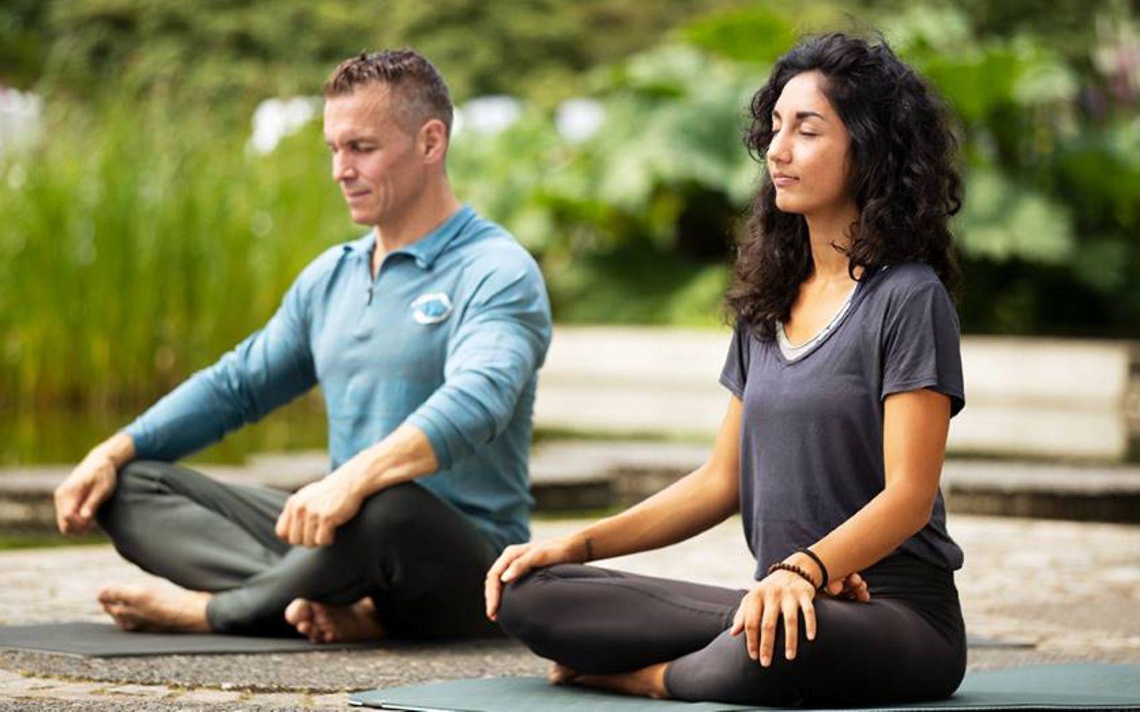 Patric Heizmann mit Yogalehrerin Sara Lyn im Yogasitz