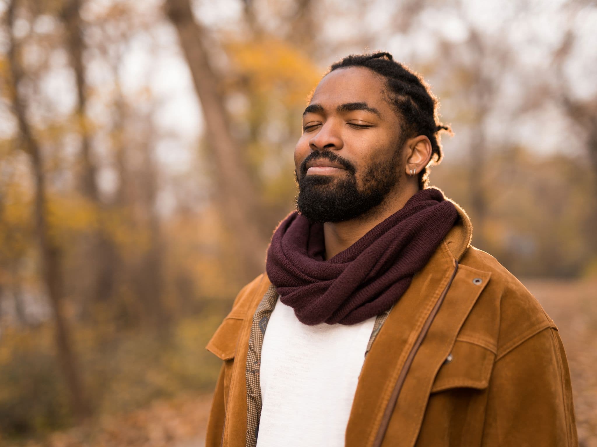 Atemübungen gegen Stress und Angst: Ein Mann steht im Wald und atmet bewusst
