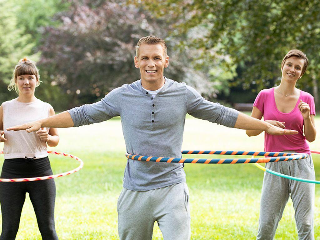 Hula Hoop: Patric Heizmann trainiert gemeinsam mit zwei Frauen im Park