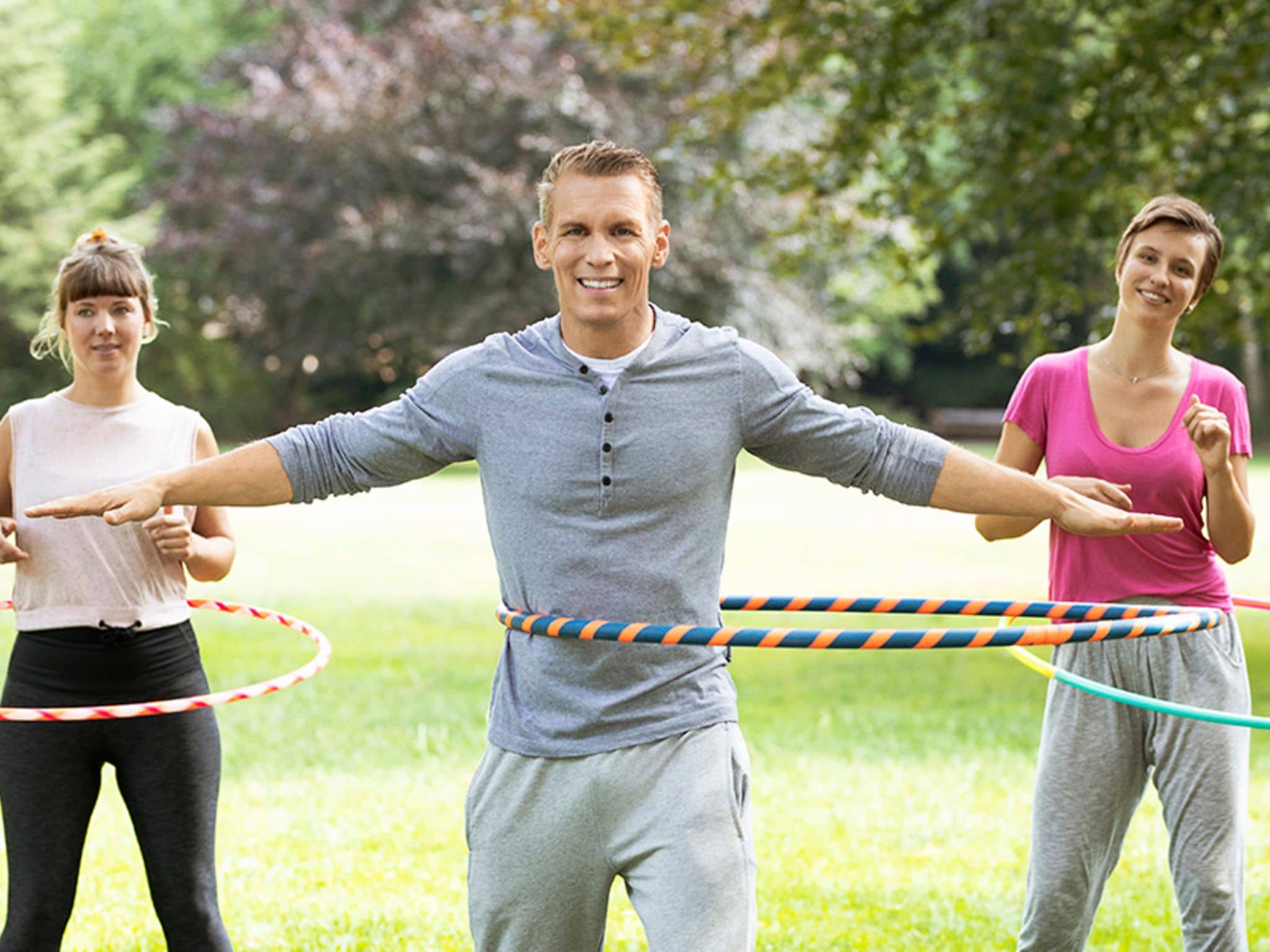 Hula Hoop: Patric Heizmann trainiert gemeinsam mit zwei Frauen im Park