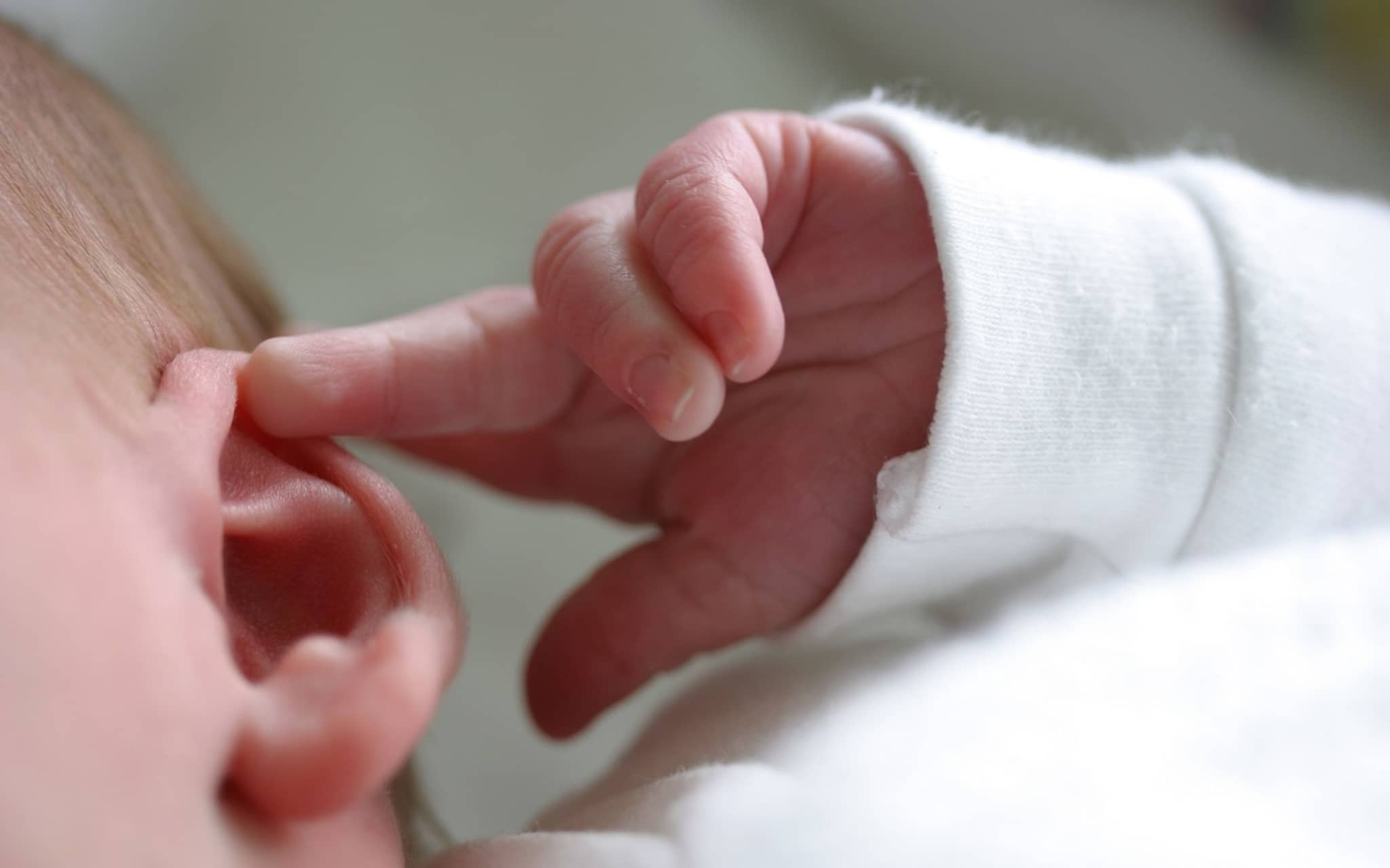 Bild: Baby greift sich ans Ohr.