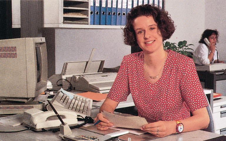 Bild: Junge Frau sitzt am Schreibtisch 1992
