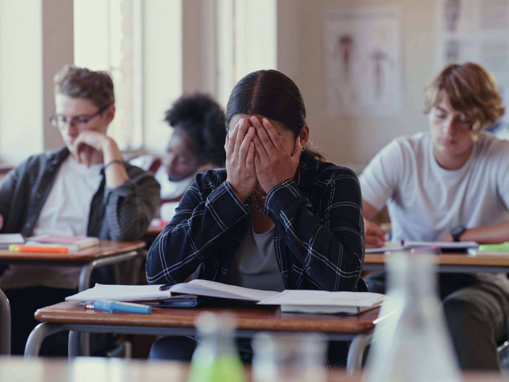 Bild: Präventionsradar 2023: Schulkind sitzt verzweifelt im Klassenraum.