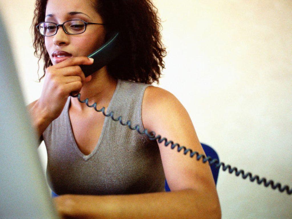 Symbolbild: Telefonische Krankmeldung: Frau in einer Praxis telefoniert