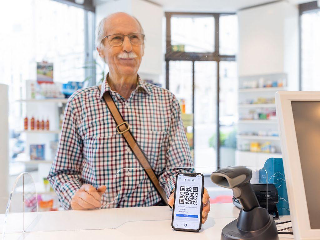Bild: Älterer Mann löst per E-Rezept App ein E-Rezept in der Apotheke ein.