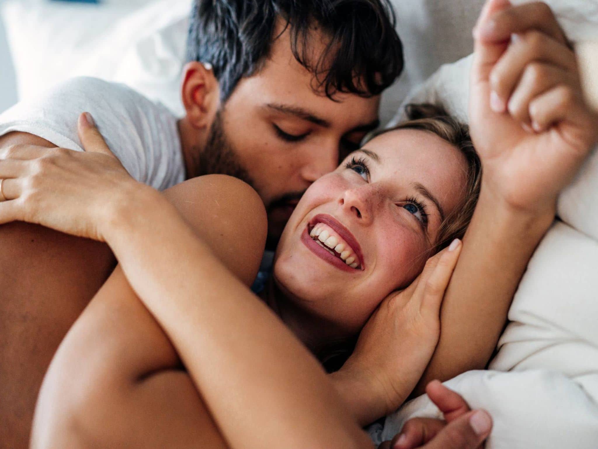 Sex in der Schwangerschaft: Paar turtelt verliebt im Bett