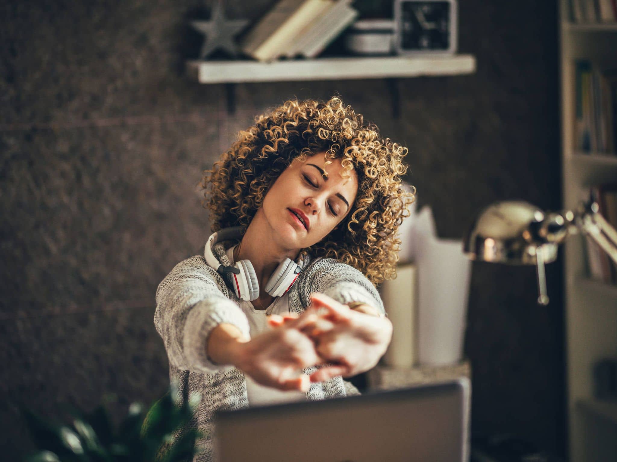 Bild: Frau stretch sich im Home-Office.
