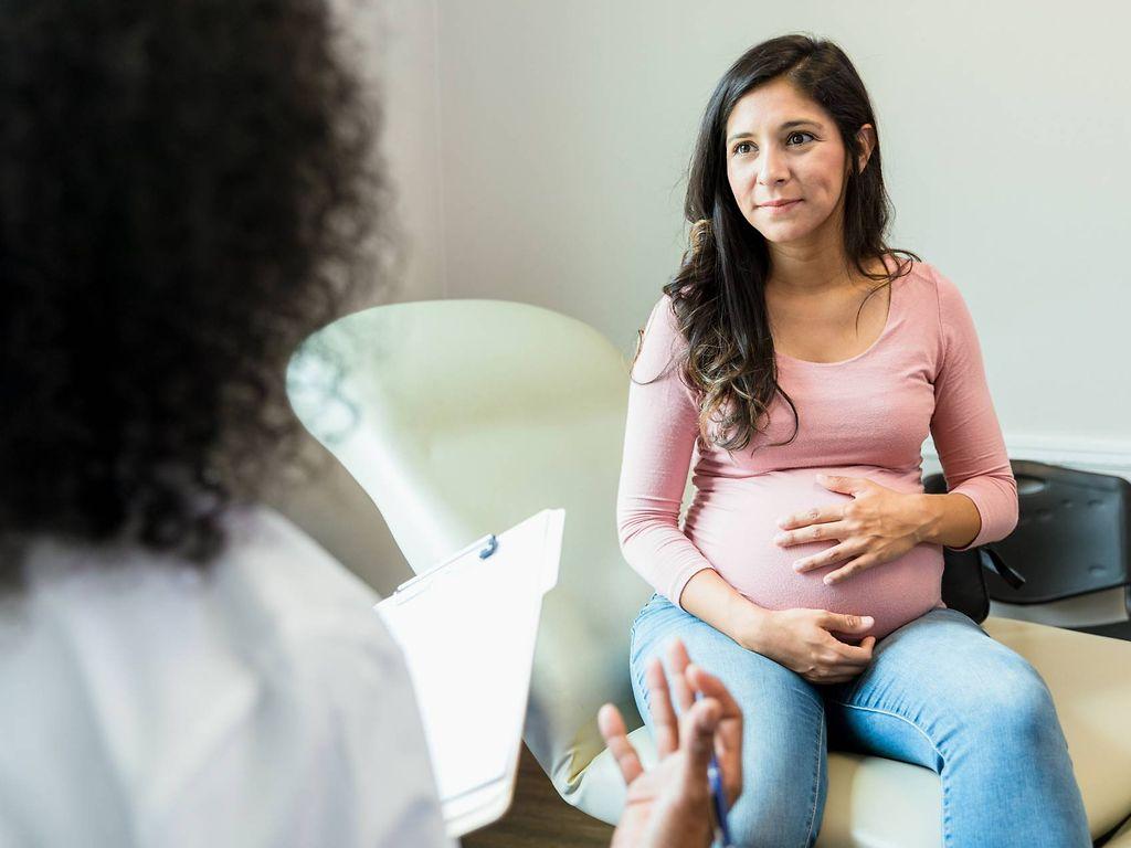 Geburt einleiten: Schwangere spricht mit Ärztin