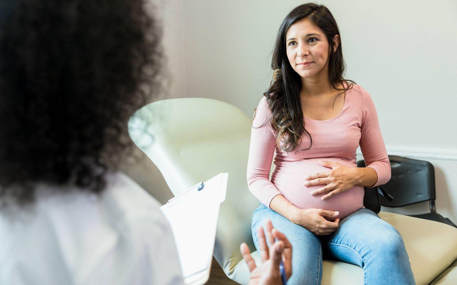 Geburt einleiten: Schwangere spricht mit Ärztin
