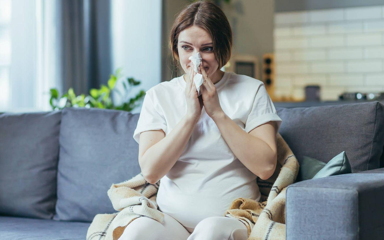Erkältung in der Schwangerschaft: Schwangere putzt sich die Nase
