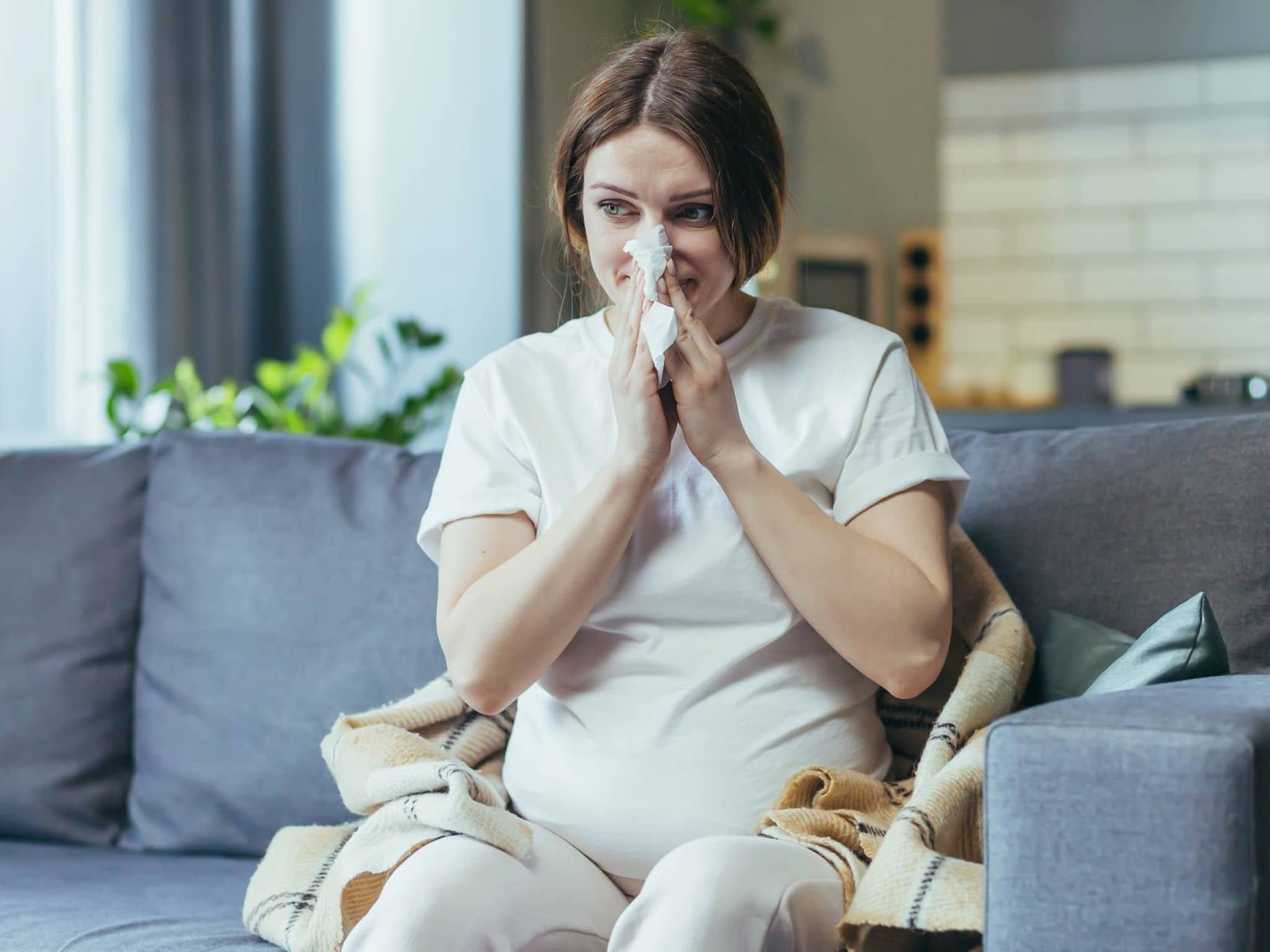 Erkältung in der Schwangerschaft: Schwangere putzt sich die Nase