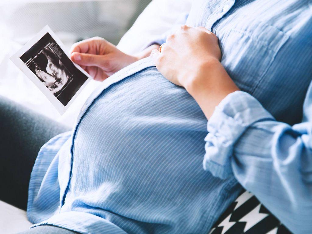 Checkliste Schwangerschaft: Schwangere betrachtet Ultraschallbild