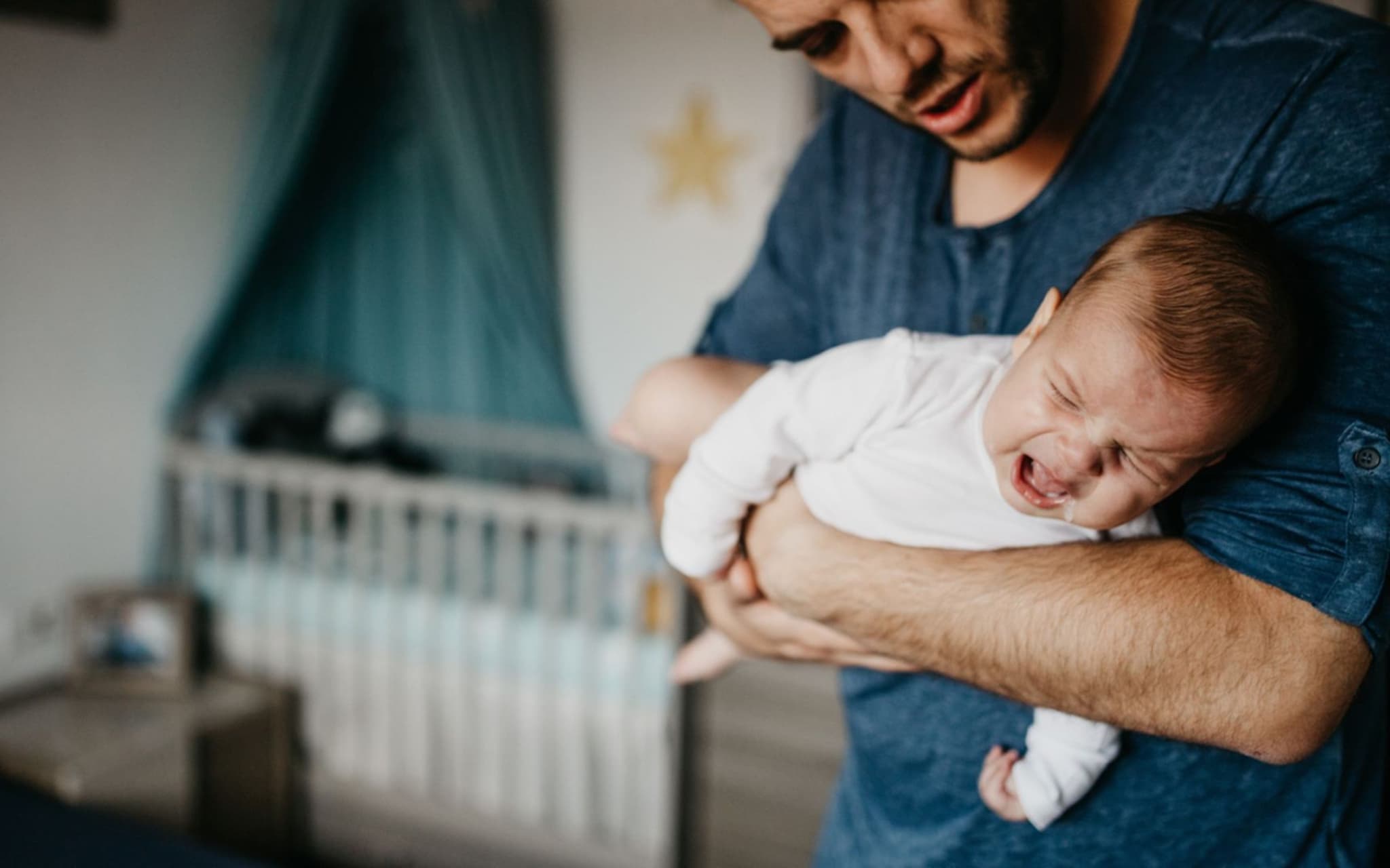 Ein Vater beruhigt sein Baby, das Magen-Darm-Probleme hat