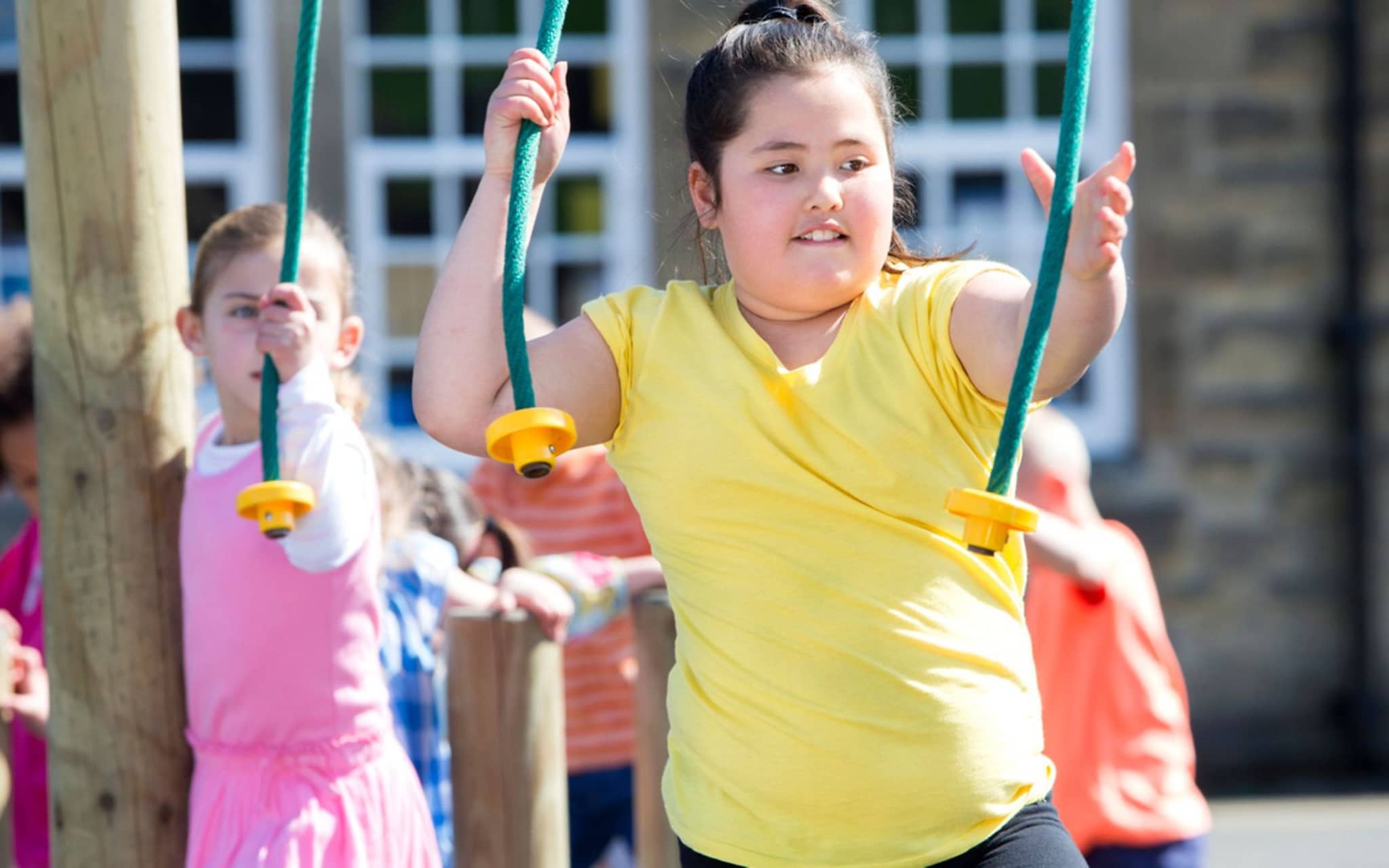 Übergewicht bei Kindern: Ein übergewichtiges Mädchen sitzt auf einer Schaukel