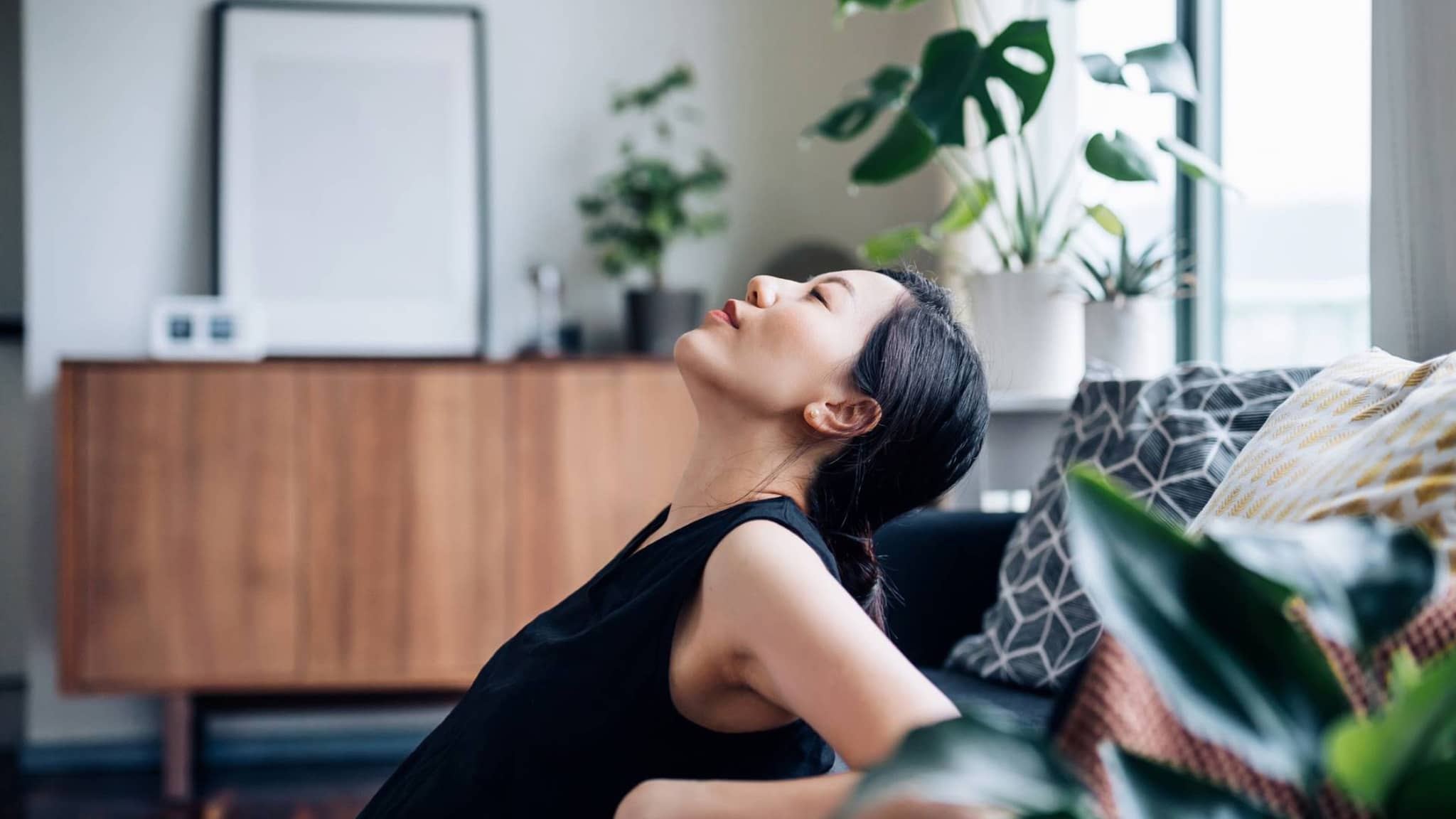 Sport und Regeneration: Junge Frau lehnt sich entspannt gegen das Sofa