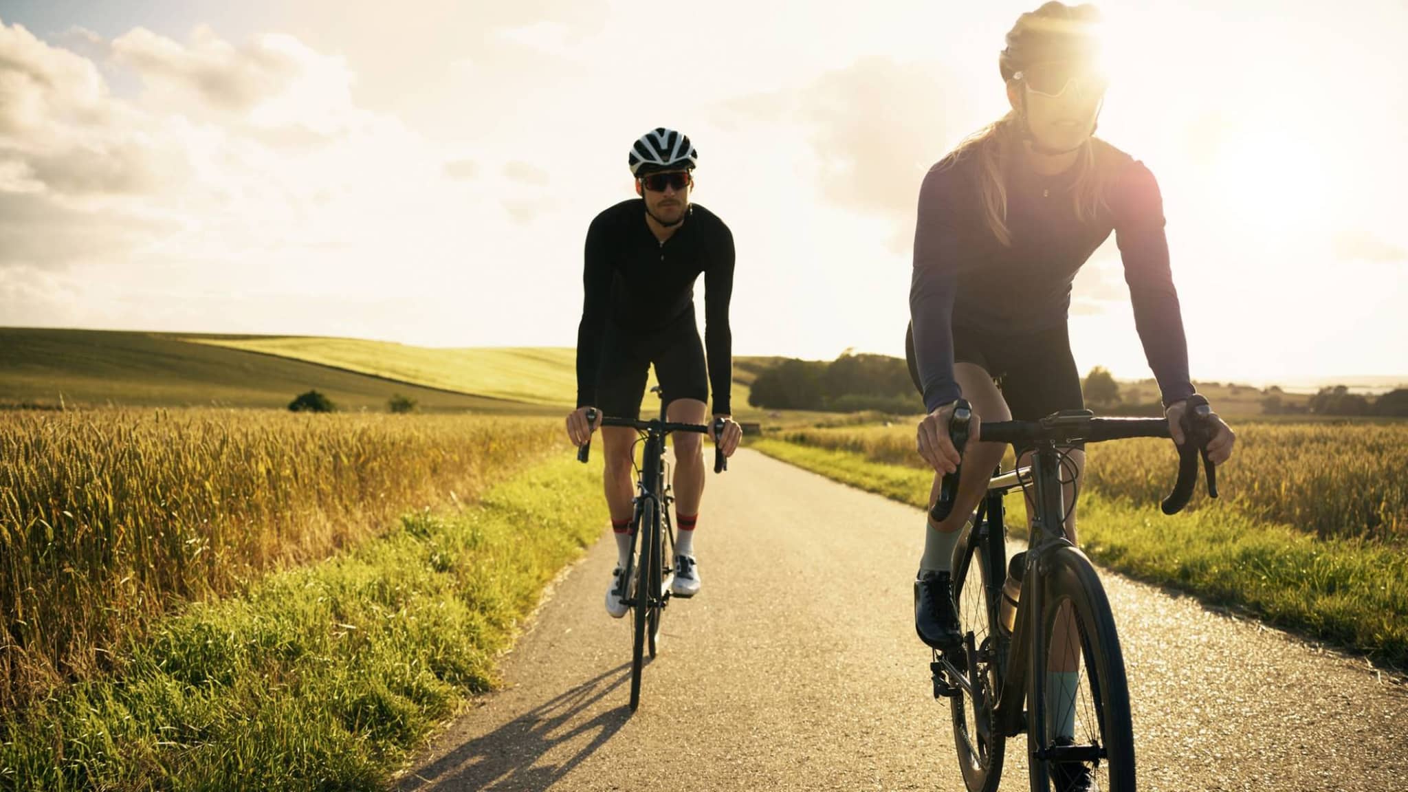 Eine Frau und ein Mann halten sich fit, indem beide im Freien Rad fahren.