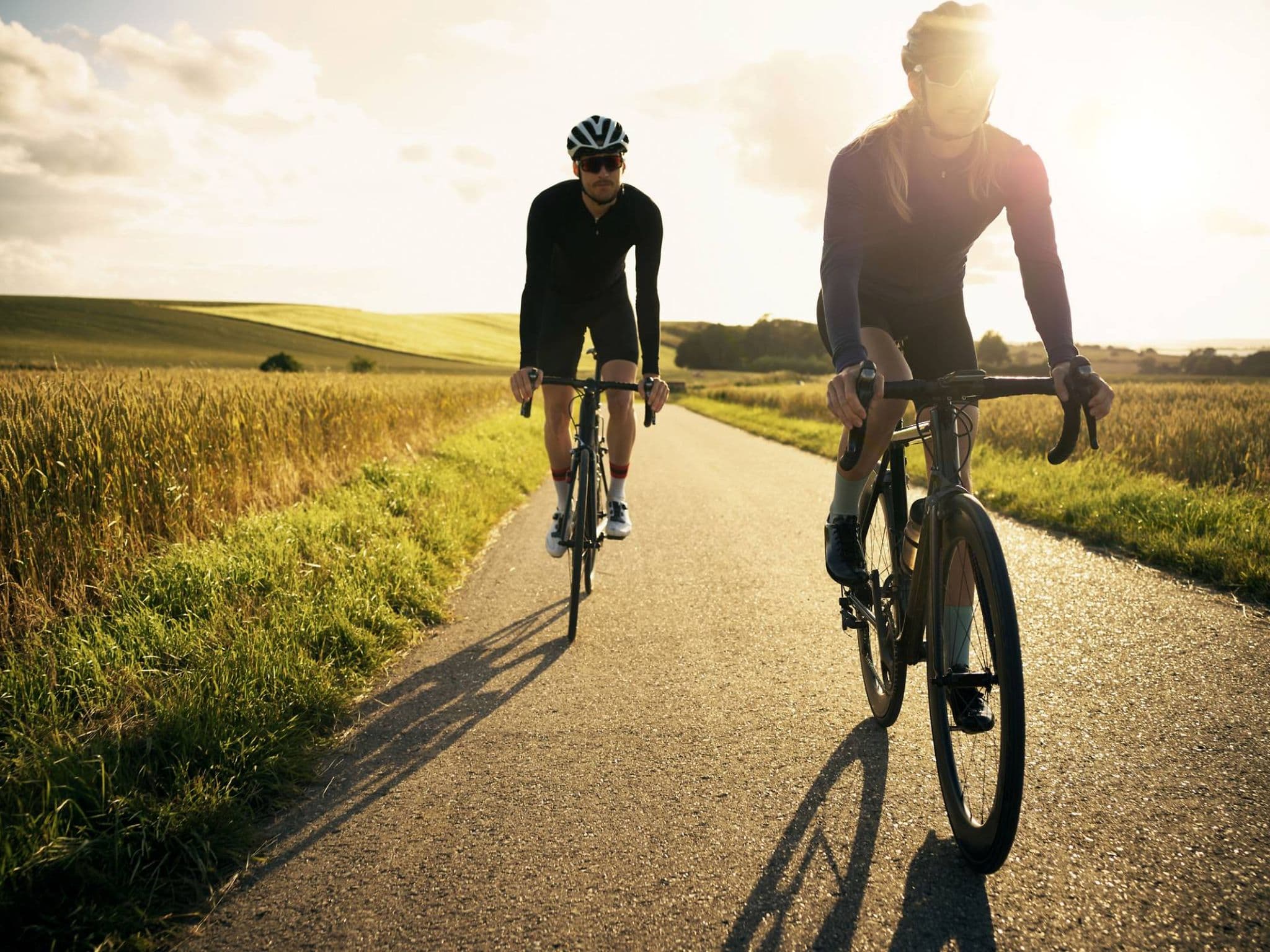 Eine Frau und ein Mann halten sich fit, indem beide im Freien Rad fahren.
