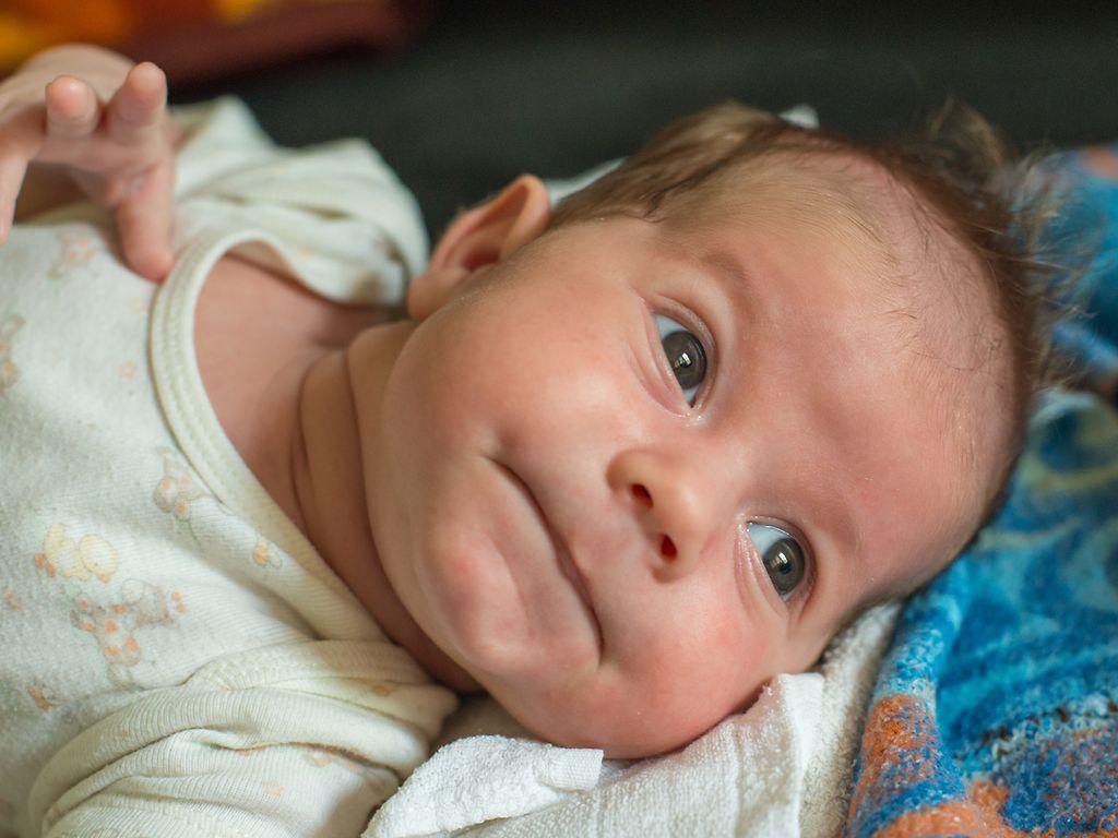 Erste Hilfe beim Baby: Ein Baby liegt auf einer Decke