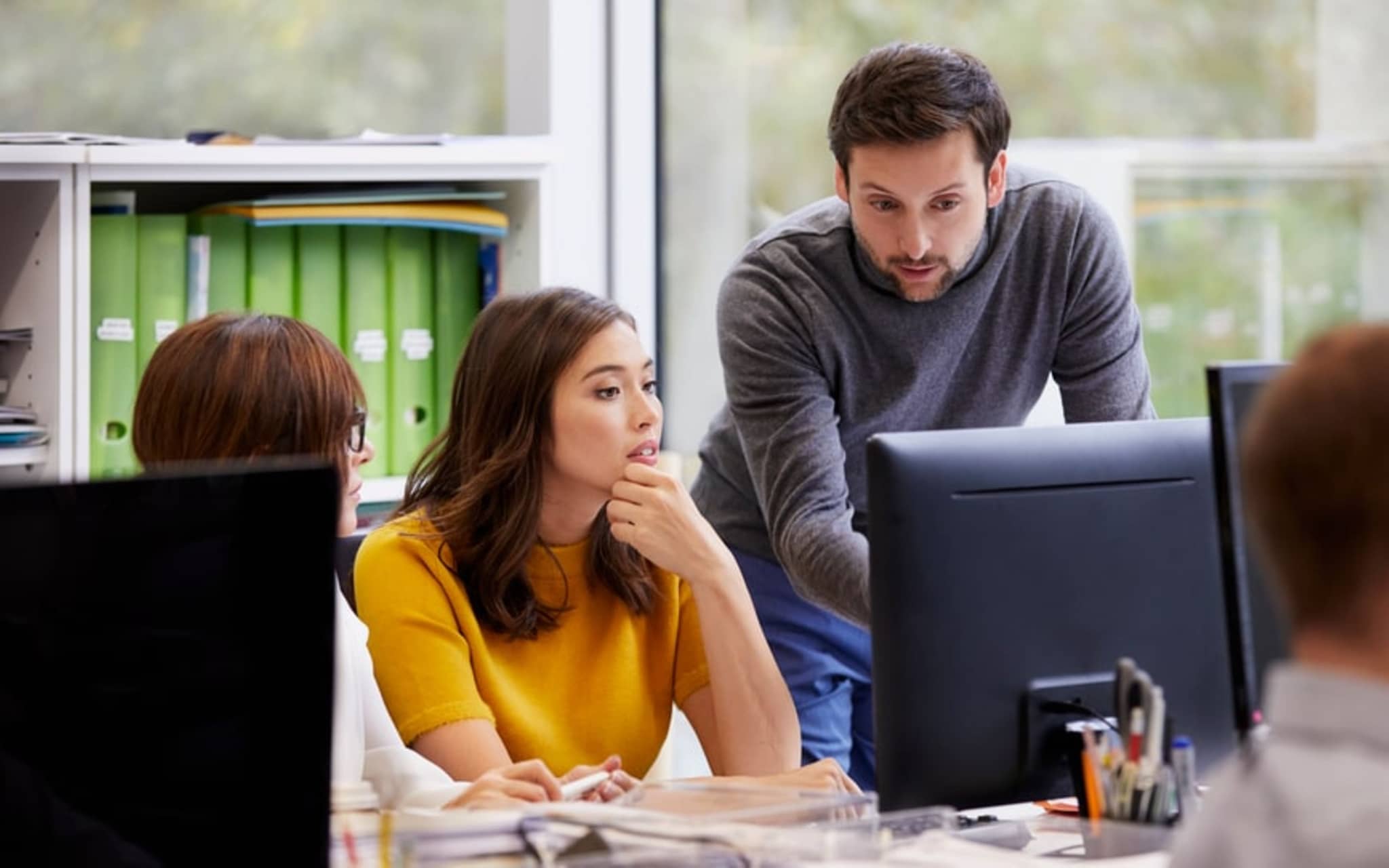 Arbeitgeber-Newsletter: Frau und Mann im Gespräch am Schreibtisch