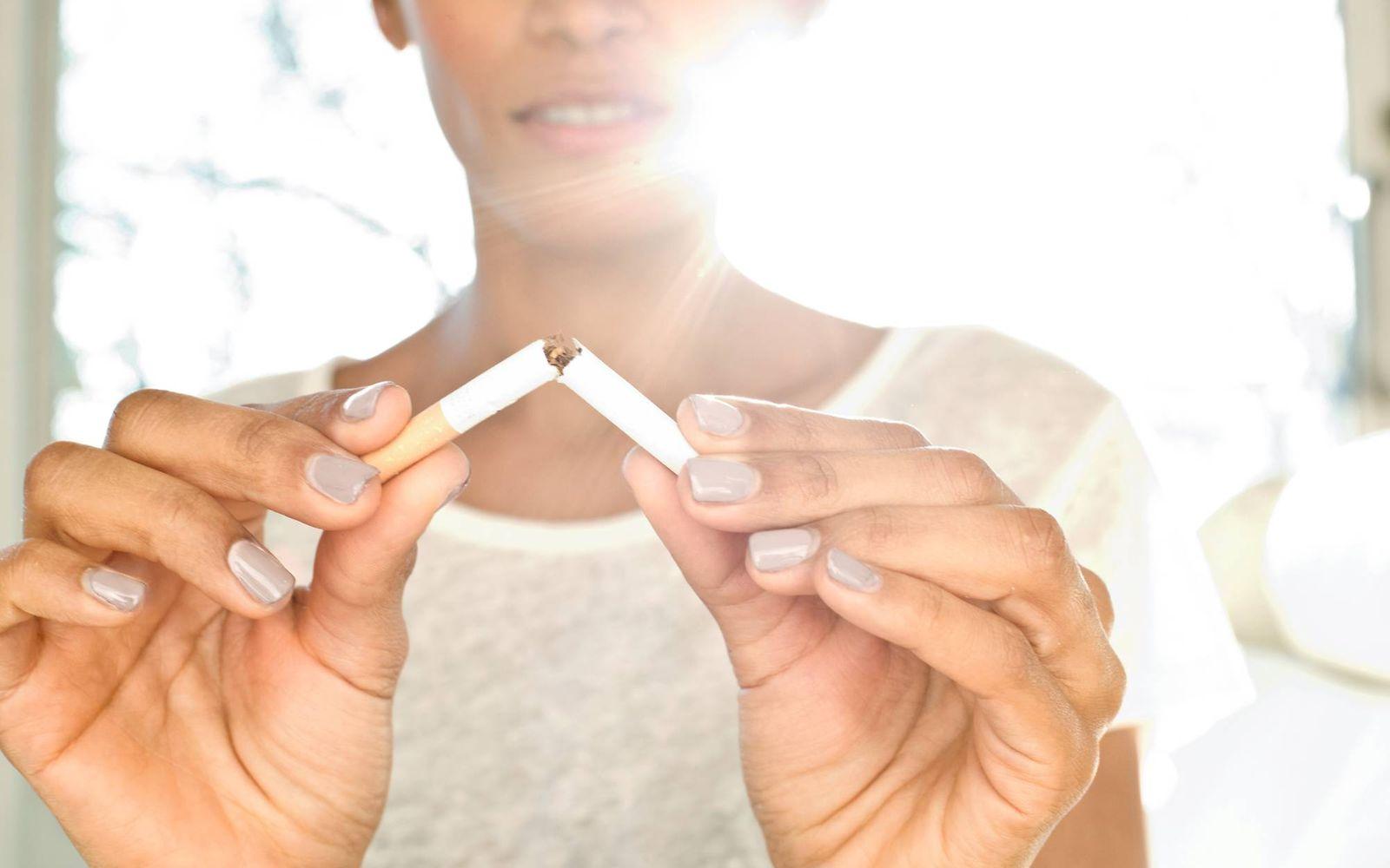 Bild: Frau bricht Zigarette entzwei, um ihre Nikotinsucht zu beenden.