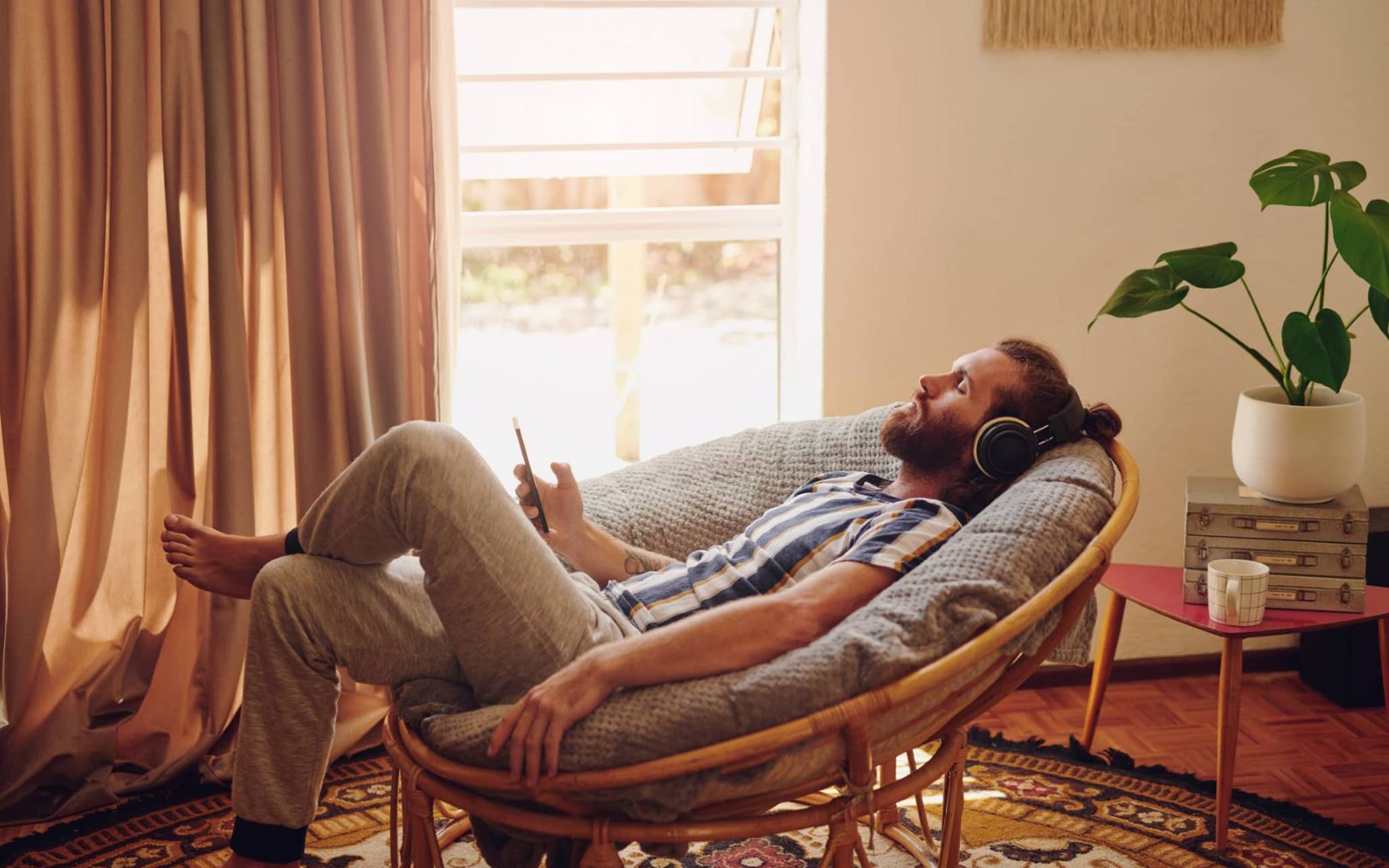 Entspannungstechniken: Mann liegt im Stuhl und hört entspannt Musik