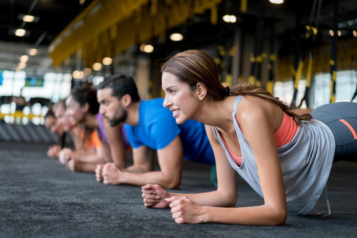 Frauen und Männer trainieren gemeinsam in einem Fitnesskurs.