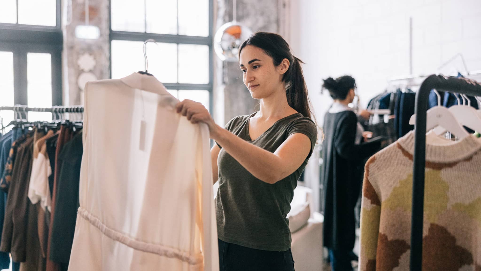 Bild: Mitarbeitende bei H&M hängt Kleidung im Showroom zurück