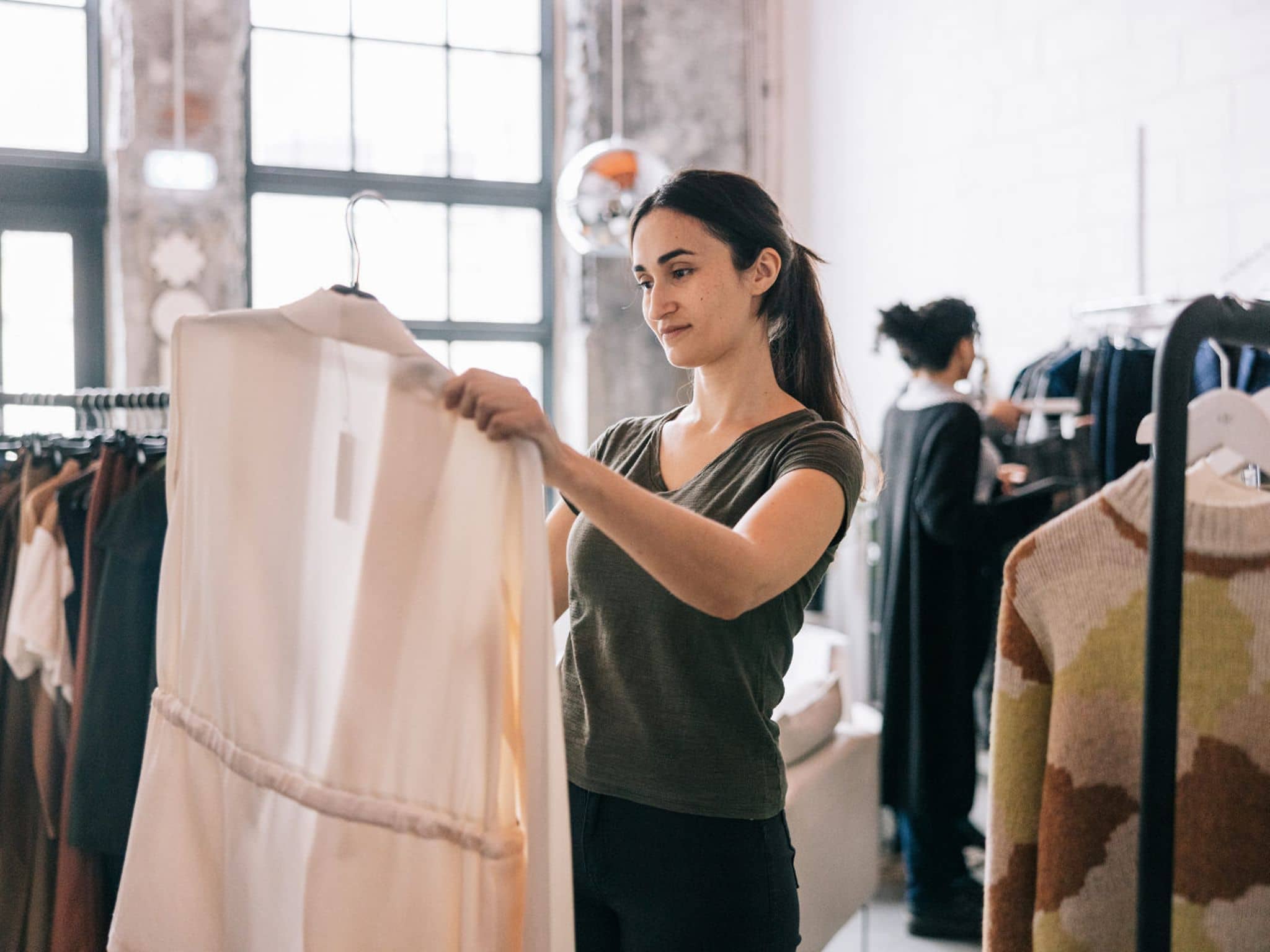 Bild: Mitarbeitende bei H&M hängt Kleidung im Showroom zurück