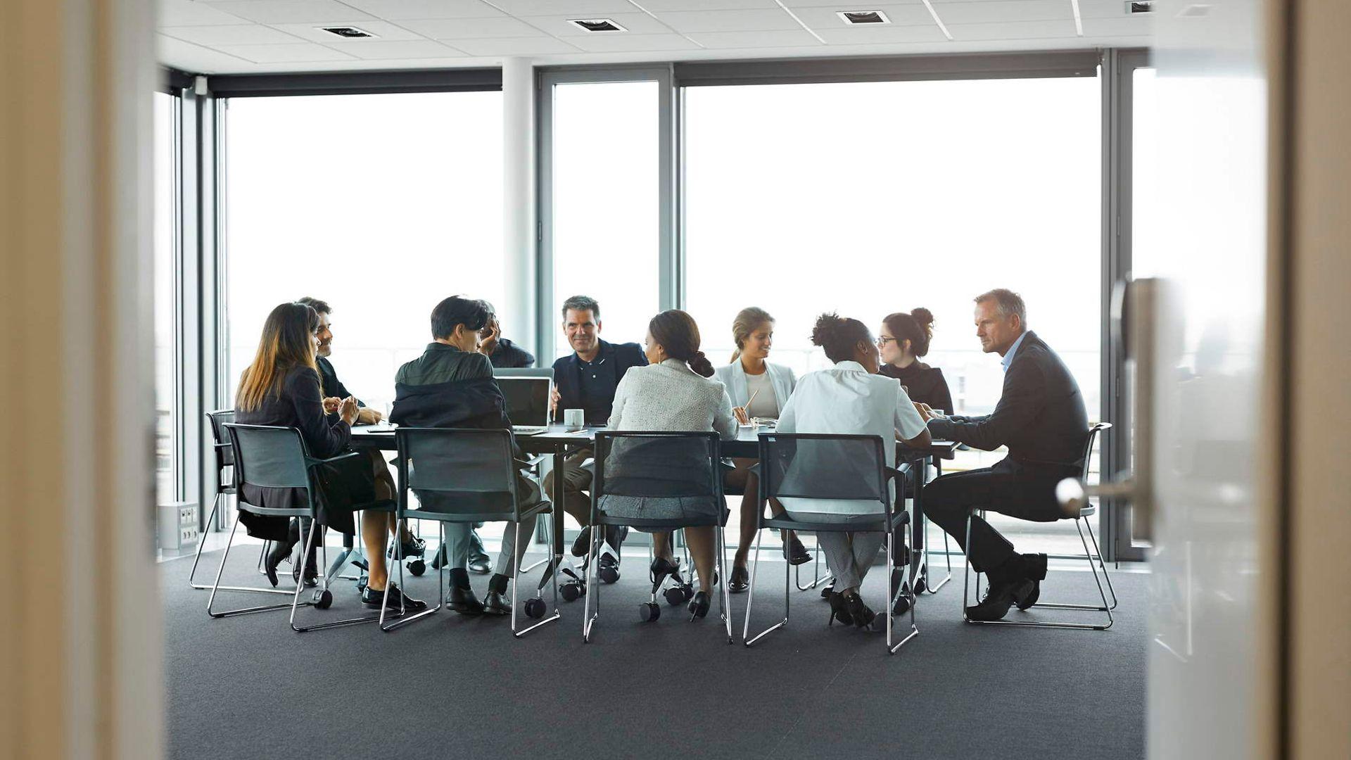 Bild: Symbolbild Menschen sitzen an einem Konferenztisch