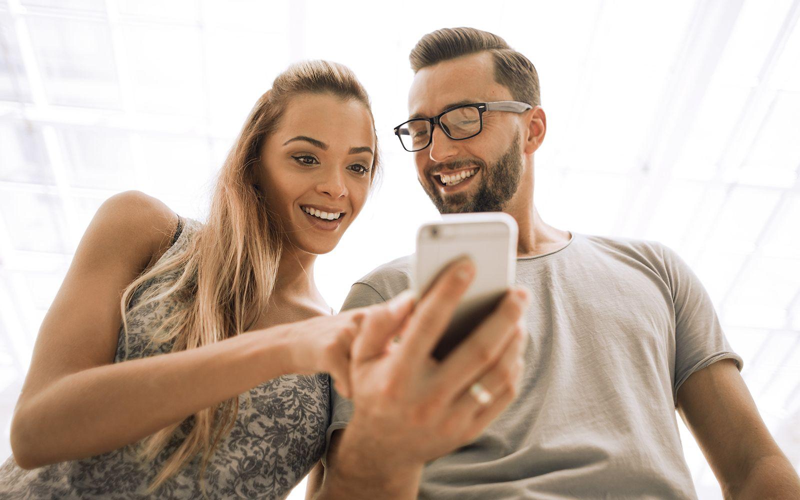 Bild: Mann und Frau schauen auf ein Handy.