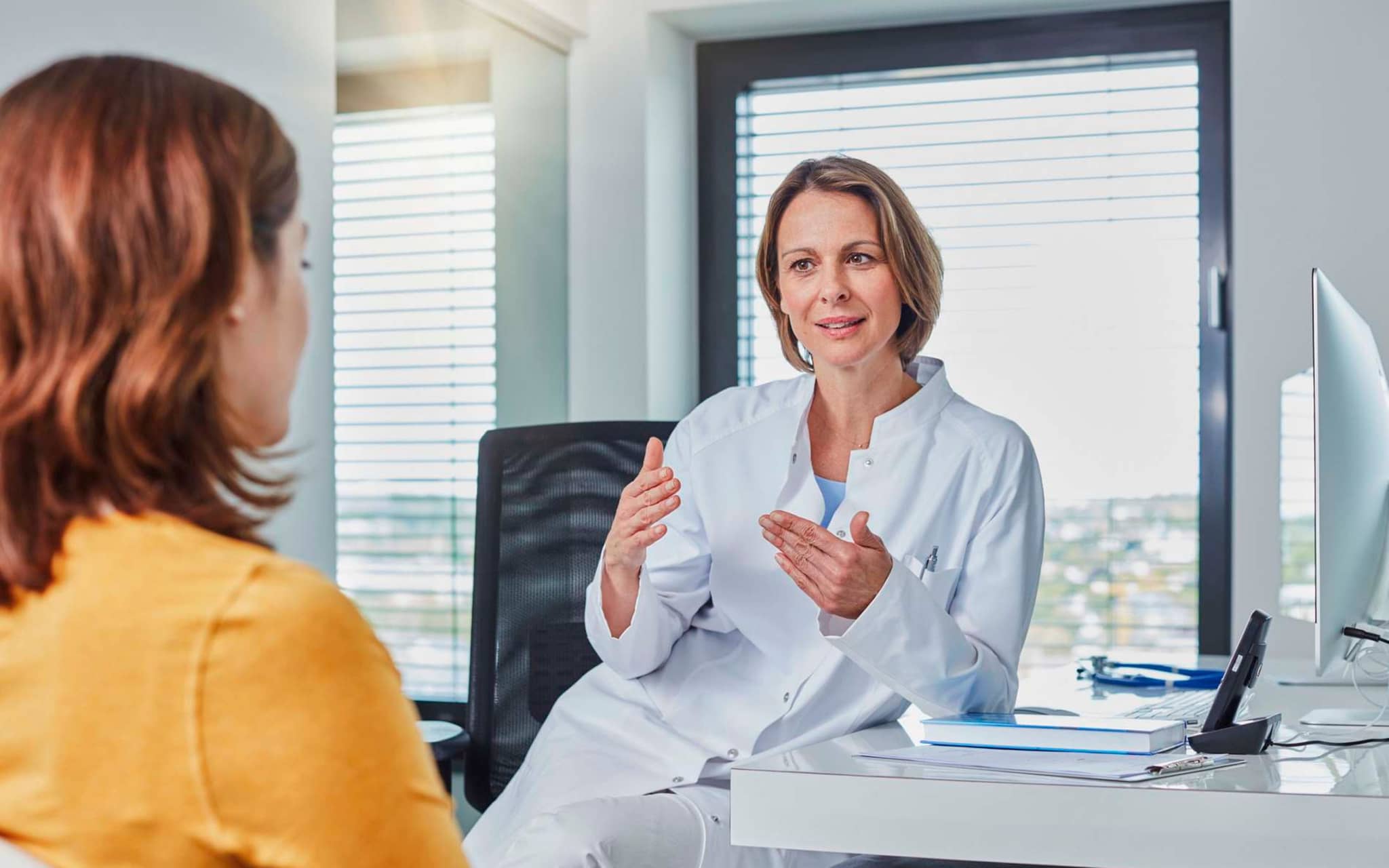 Bild: Ärztin und Patientin im Gespräch in der Praxis.