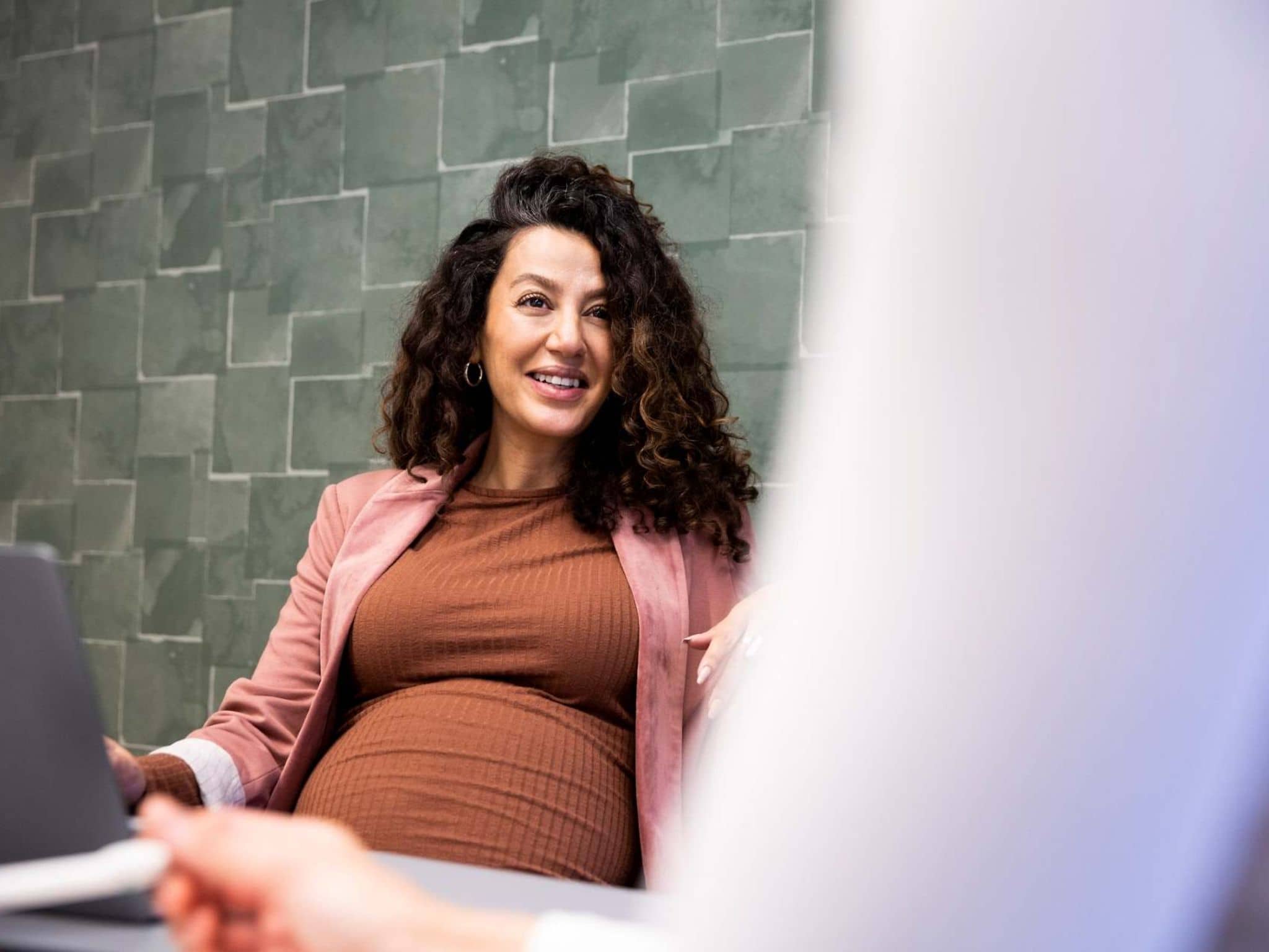 Symbolbild: Schwangere unterhält sich mit Kollegin.