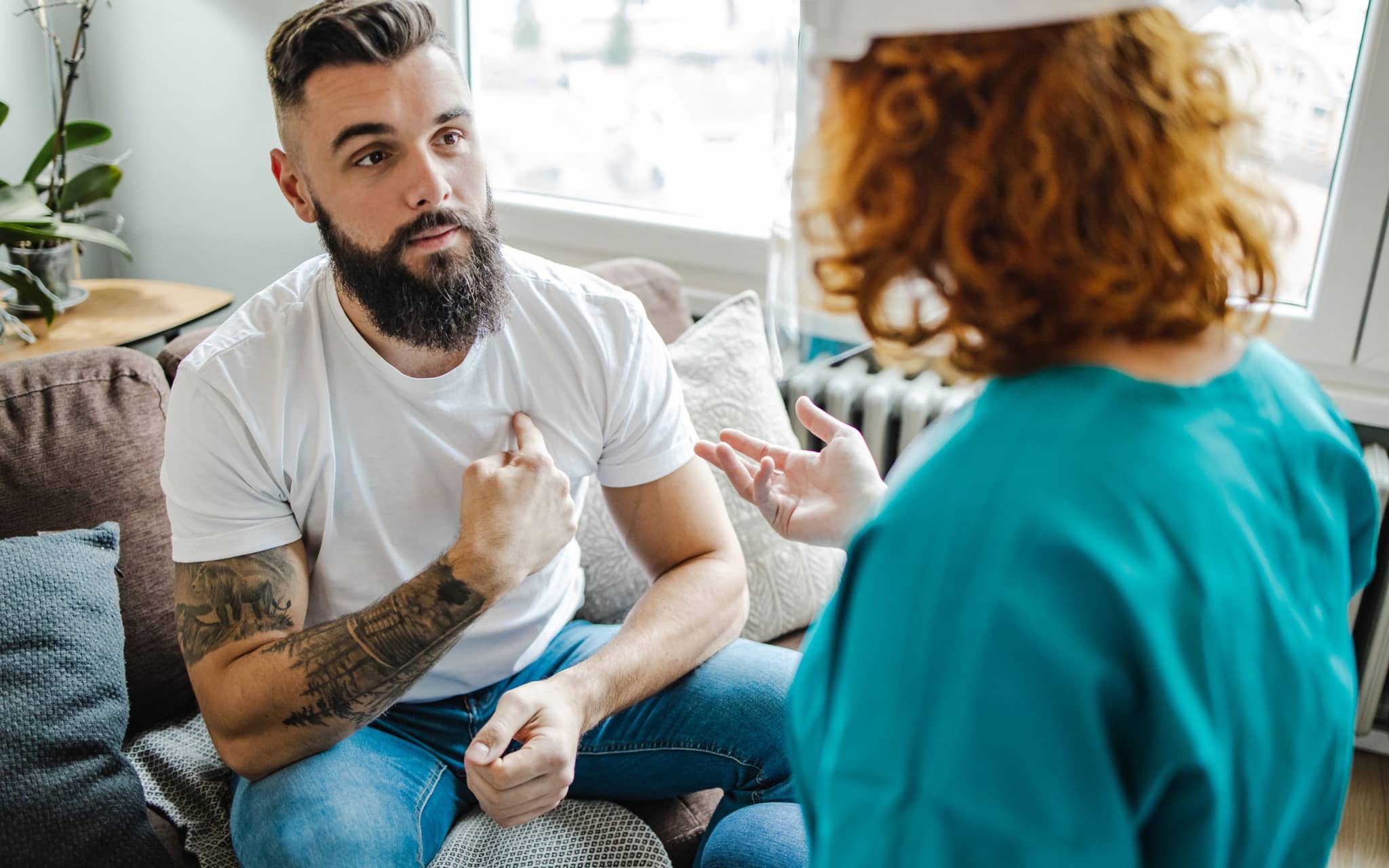 Symbolbild für STI-Test: Ein Mann hört einem Arzt in seiner Praxis zu