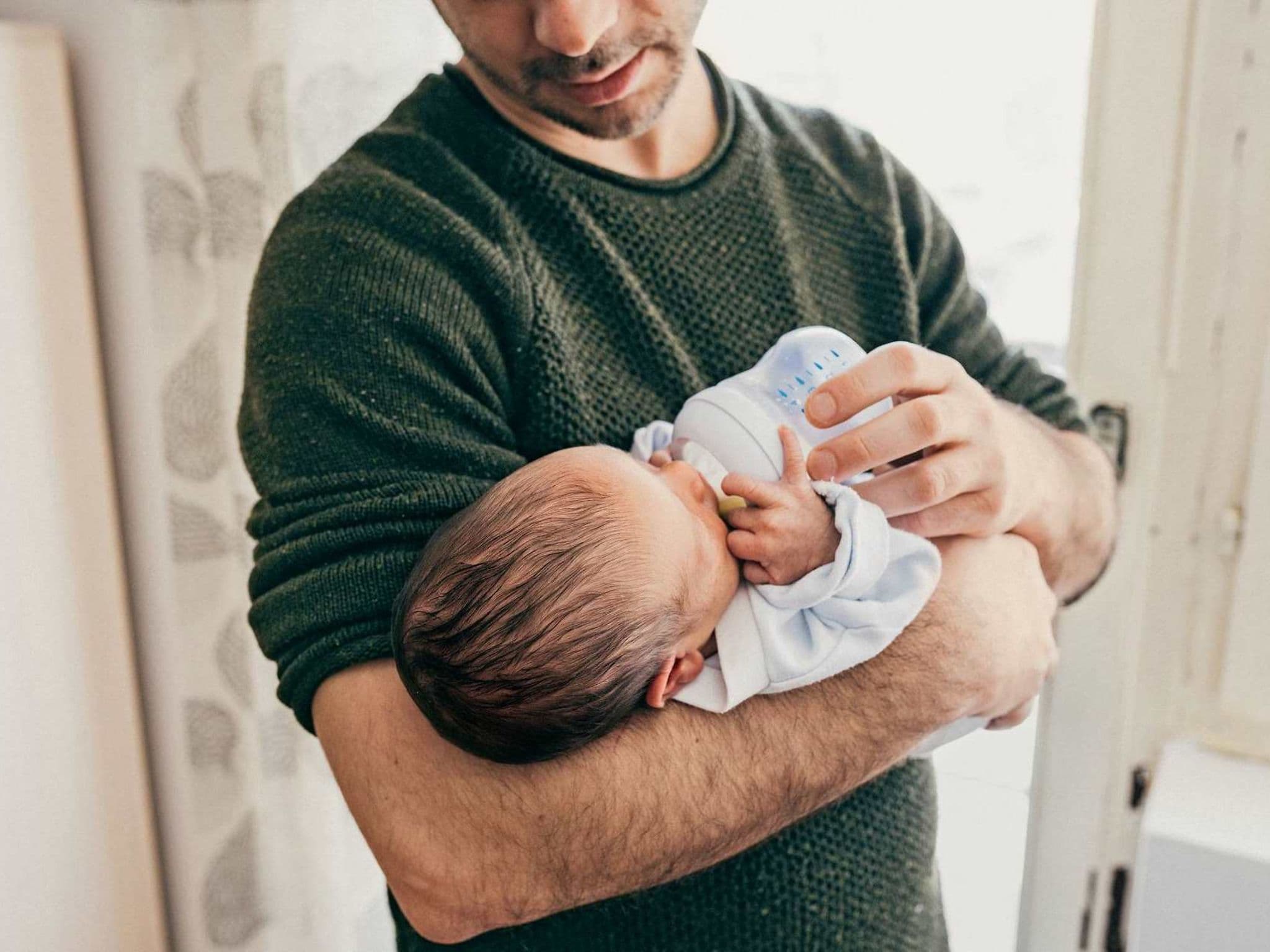 Bild: Vater gibt seinem Baby ein Fläschchen.