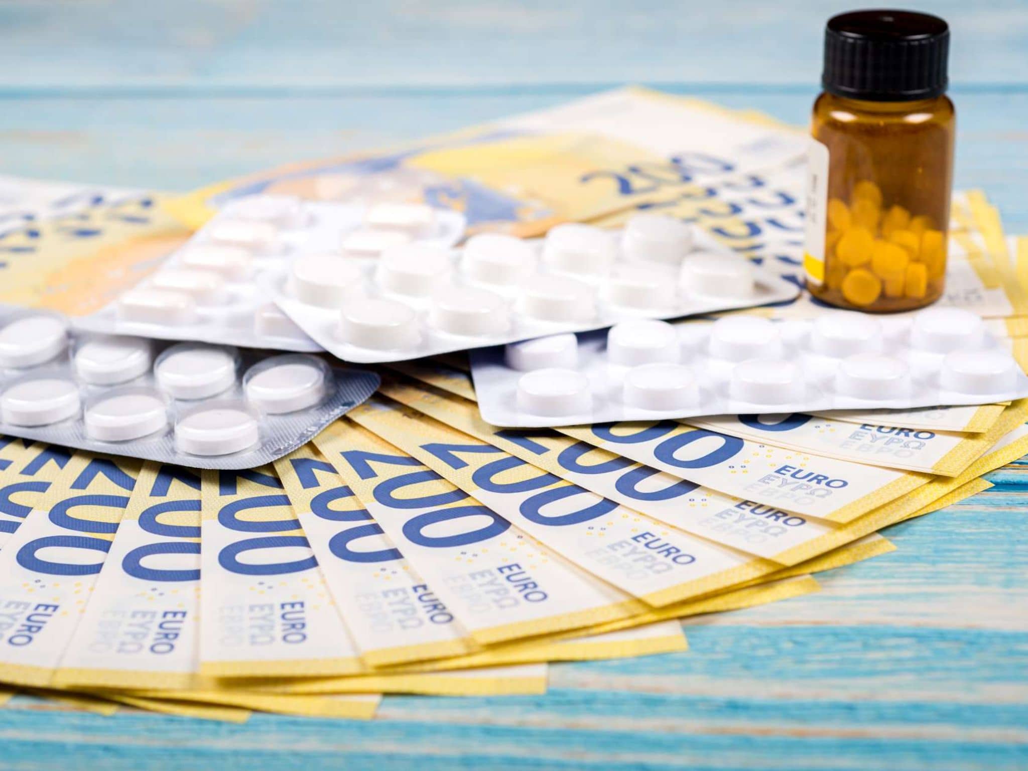 Viele Tabletten liegen auf mehreren 200-Euro-Scheinen.