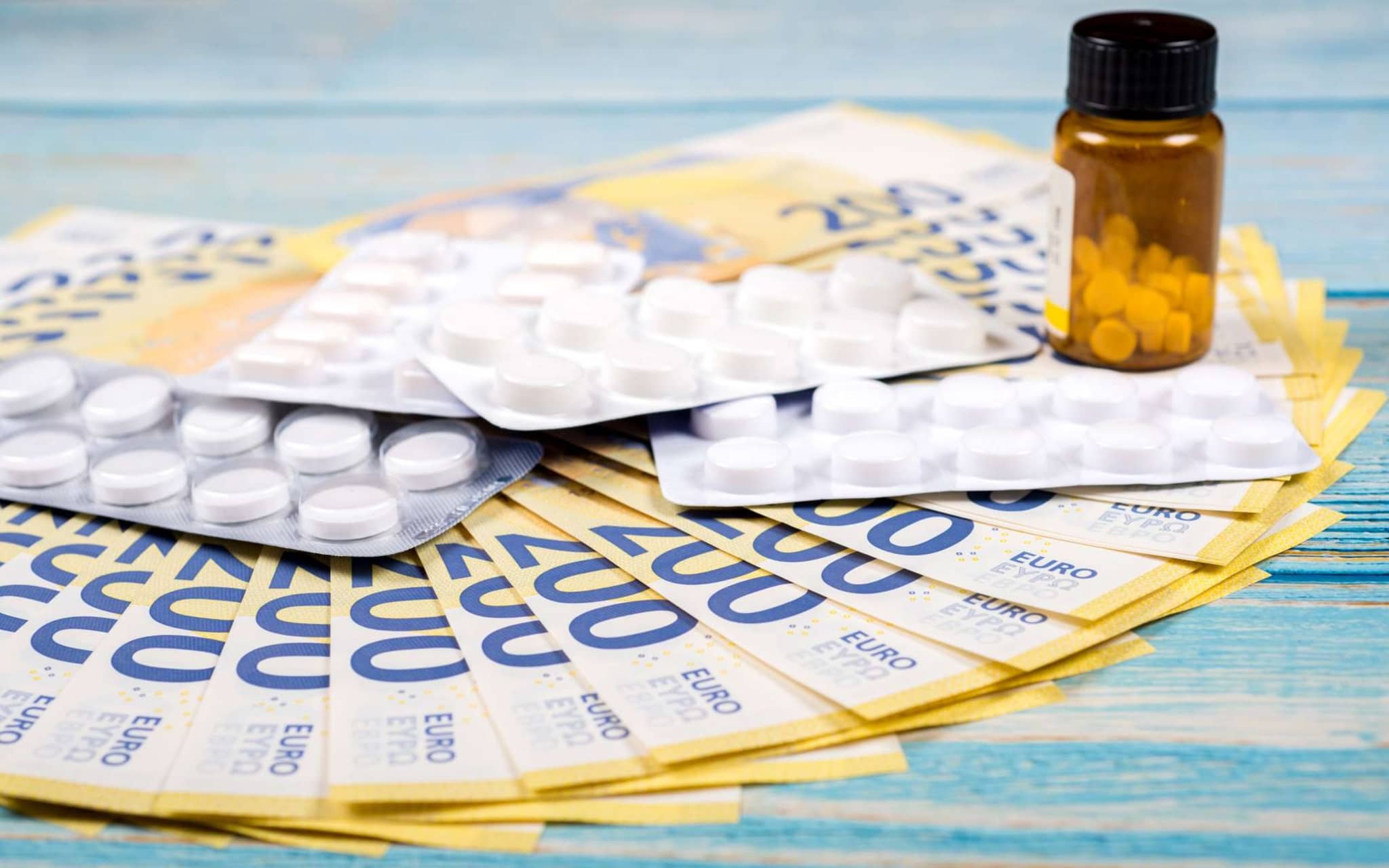 Viele Tabletten liegen auf mehreren 200-Euro-Scheinen.