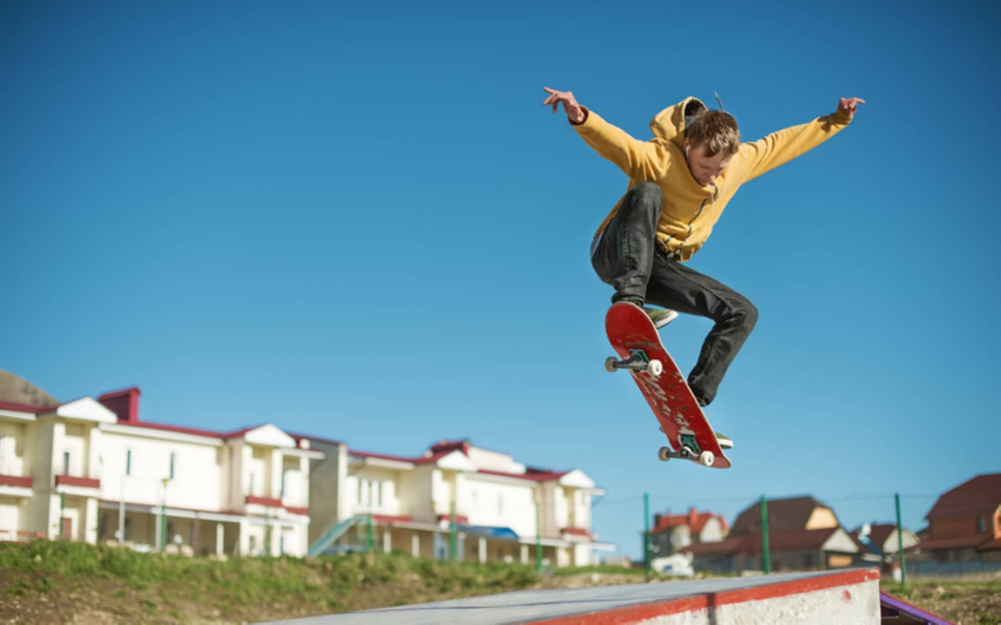 Ein Jugendlicher befindet sich mit seinem Skateboard im Höhenflug.