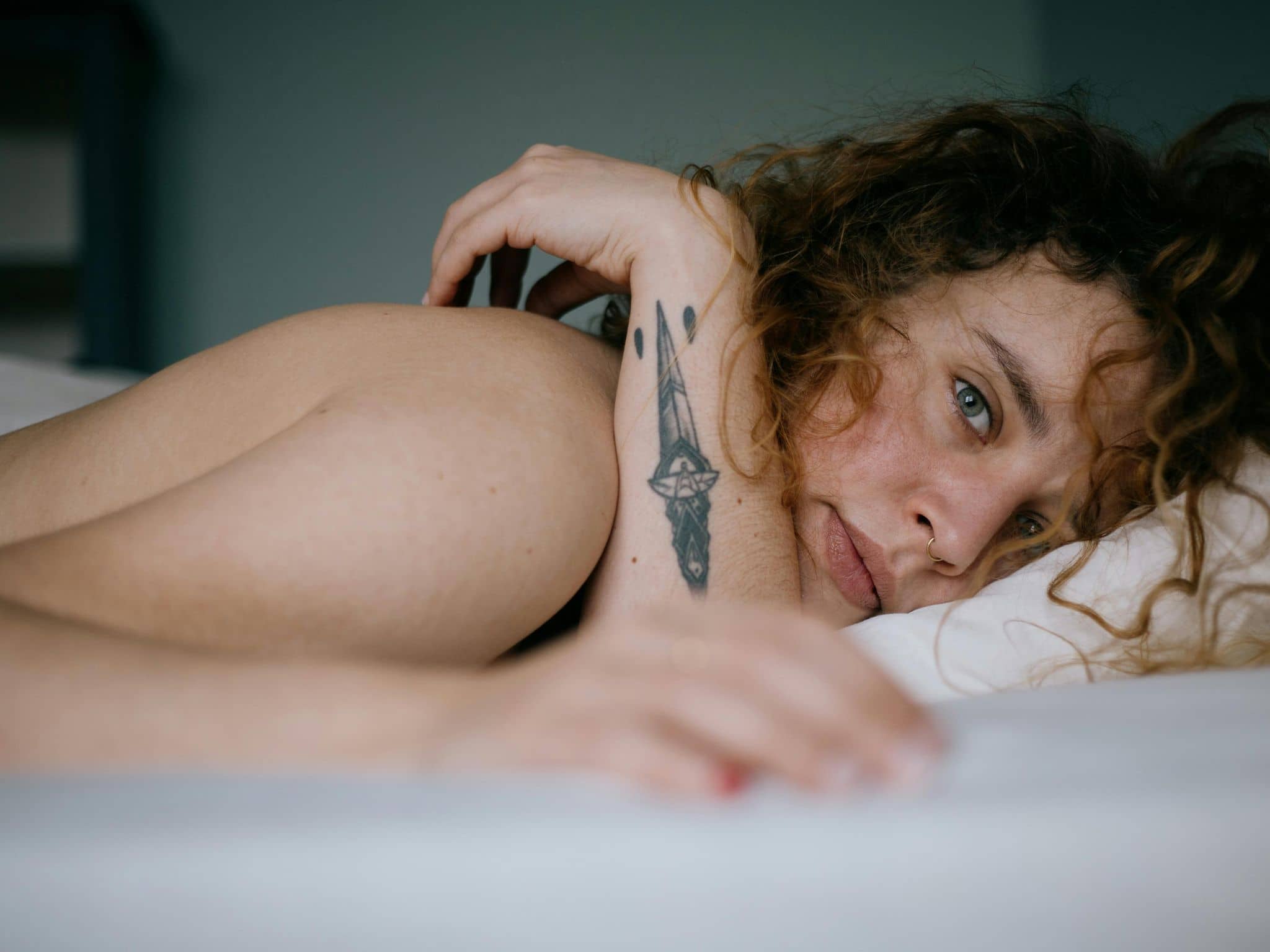 Junge Frau liegt im Bett.