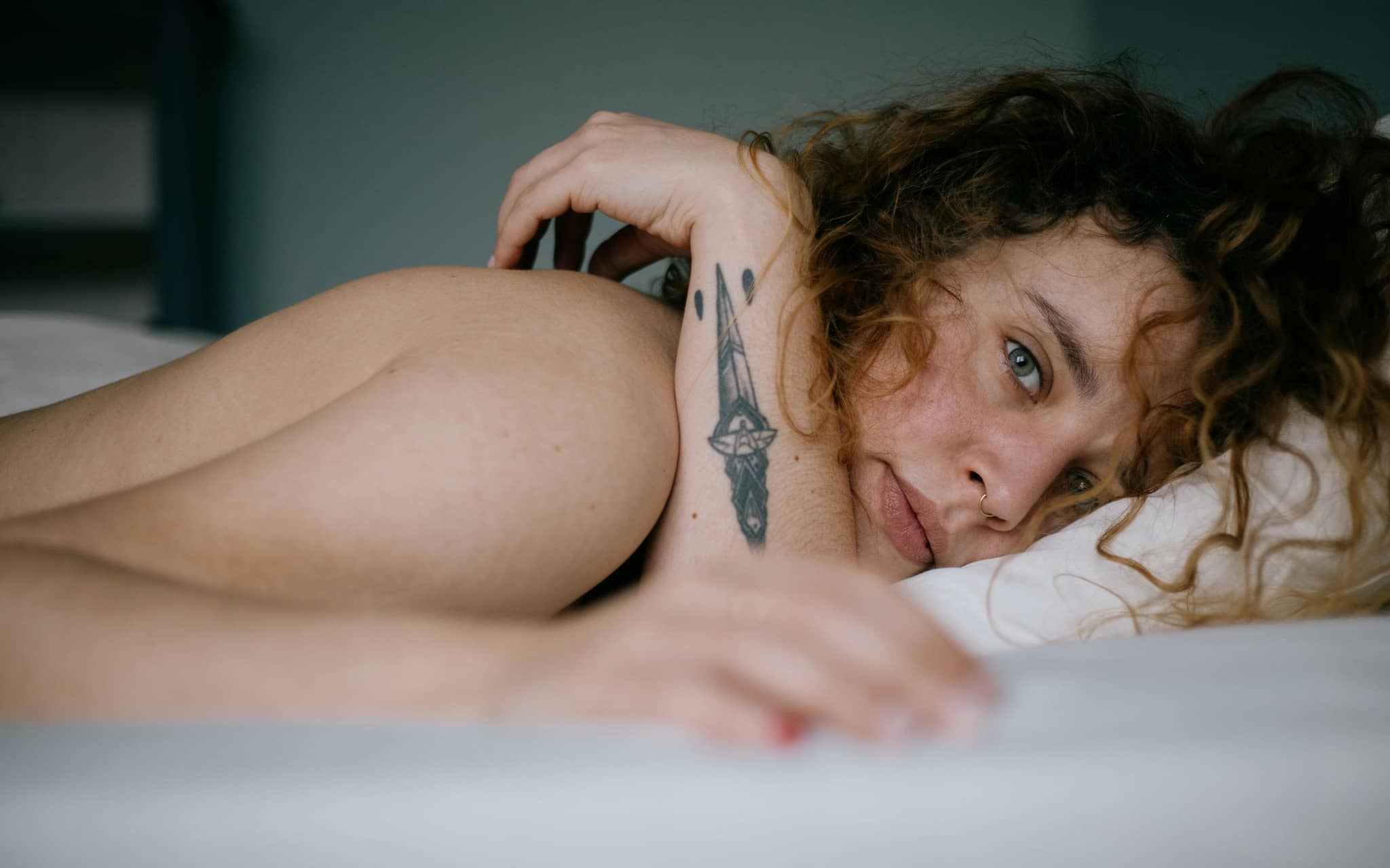 Junge Frau liegt im Bett.